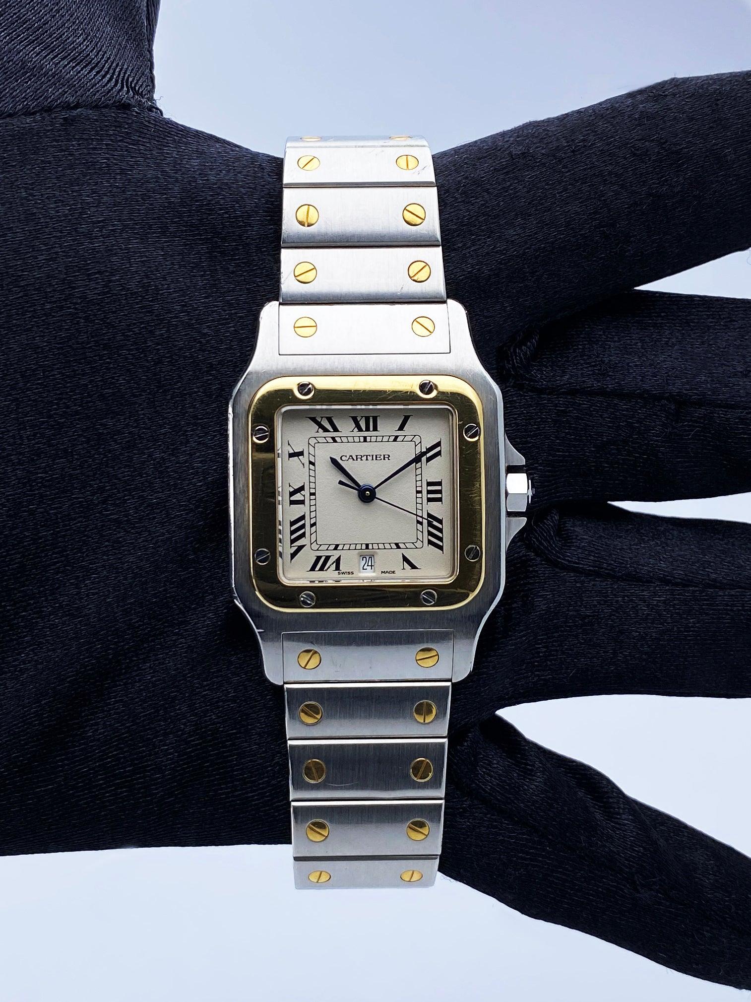 Cartier Santos Galbee Watch. 29mm stainless steel case. 18K yellow gold fixed bezel. Off-white dial with blue hands and black Roman numeral hour marker. Date display at the 6 o'clock position. Minute makers on the inner dial. 18K yellow gold and
