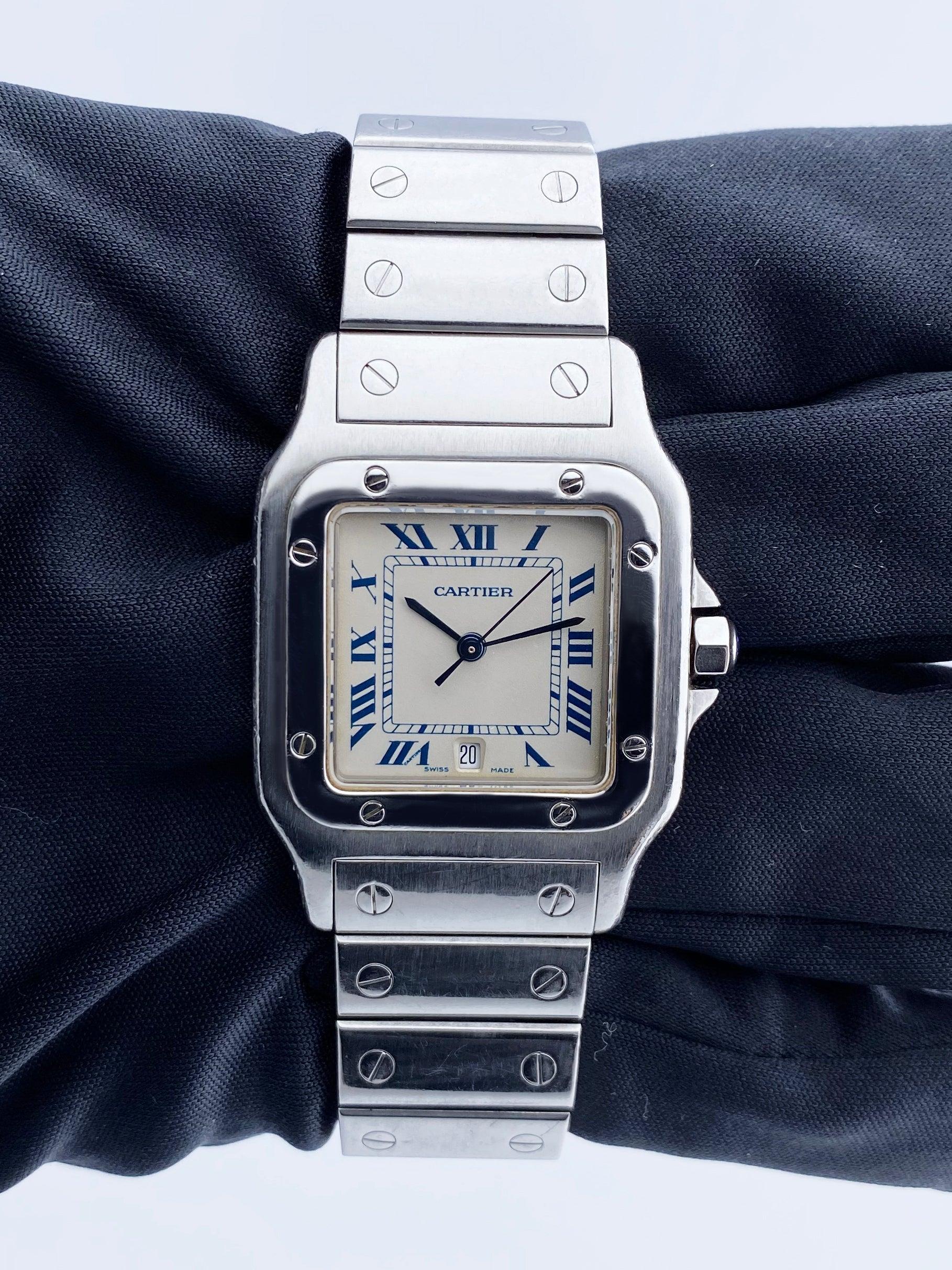 Cartier Santos Galbee 987901 Herrenuhr. 29-mm-Edelstahlgehäuse mit fester Lünette. Weißes Zifferblatt mit blauen Zeigern und schwarzen römischen Ziffern. Datumsanzeige auf der 6-Uhr-Position. Minutenzeiger auf dem inneren Zifferblatt.