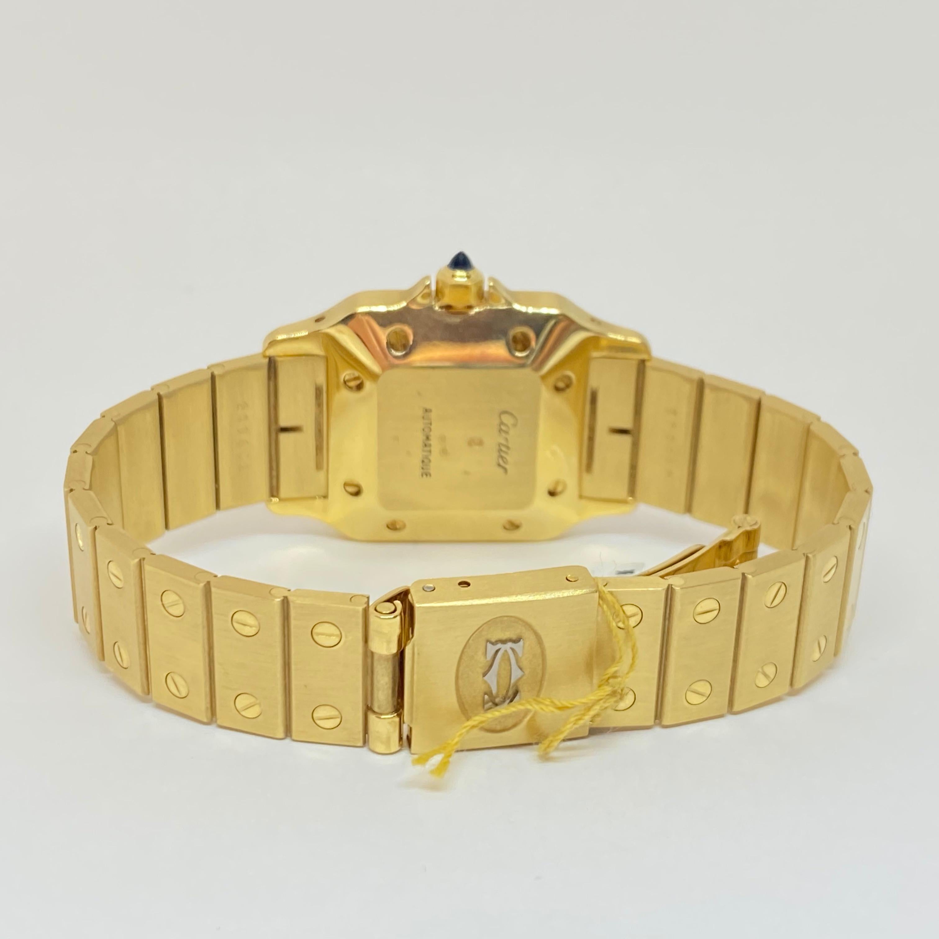 Pre-owned Cartier Santos Automatic timepiece designed in solid 18 karat yellow gold. The case measures 27 x 39mm, automatic movement, gold link bracelet, single deployant fold over clasp, blue steel hands, second hand, date window, blue crown. One