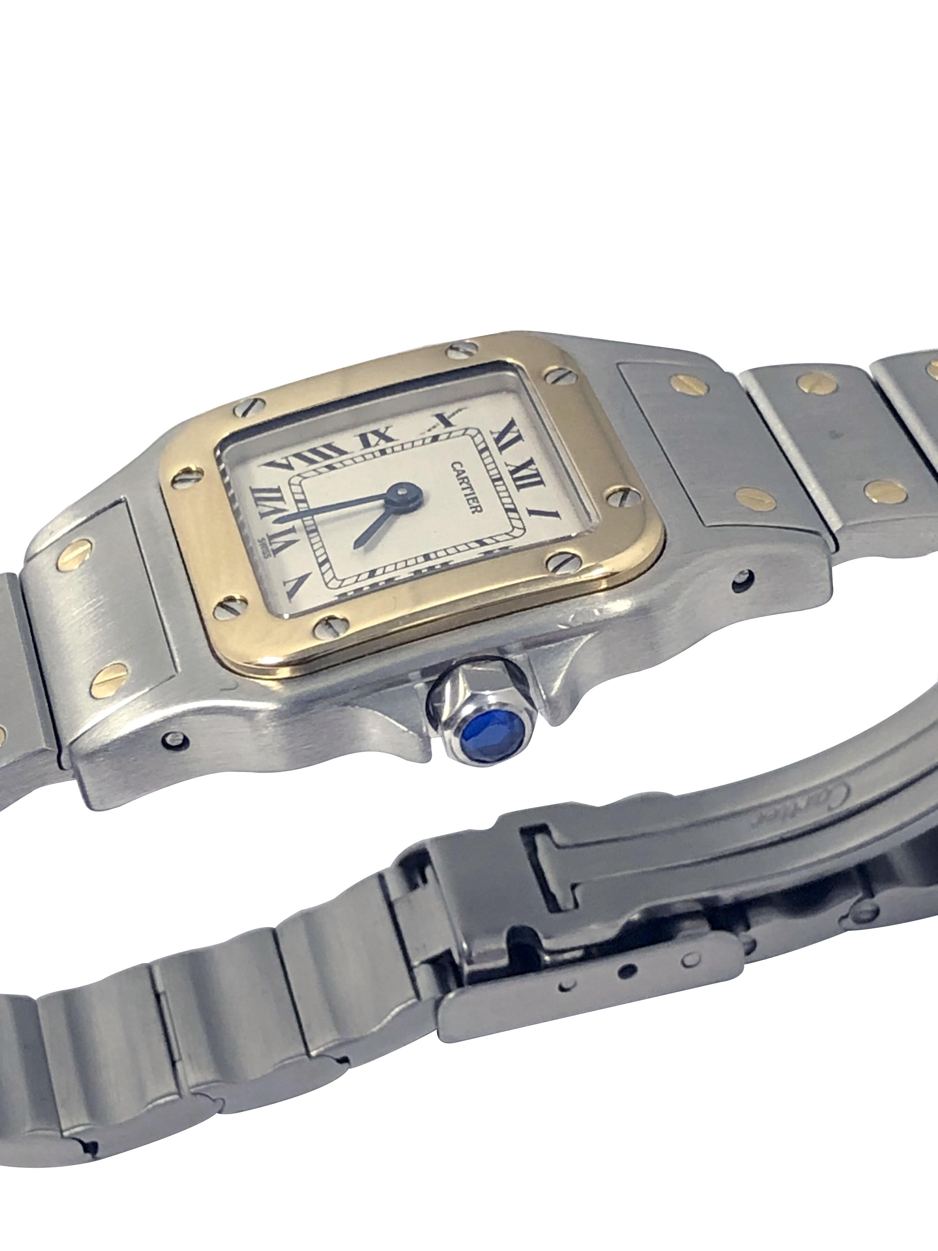 Reloj de pulsera Cartier Santos Galbee para señora, Circa 2000, caja de acero inoxidable de 24 X 24 MM con bisel de oro amarillo de 18 quilates. Movimiento de cuarzo, esfera blanca plateada con números romanos negros, corona de zafiro. Brazalete