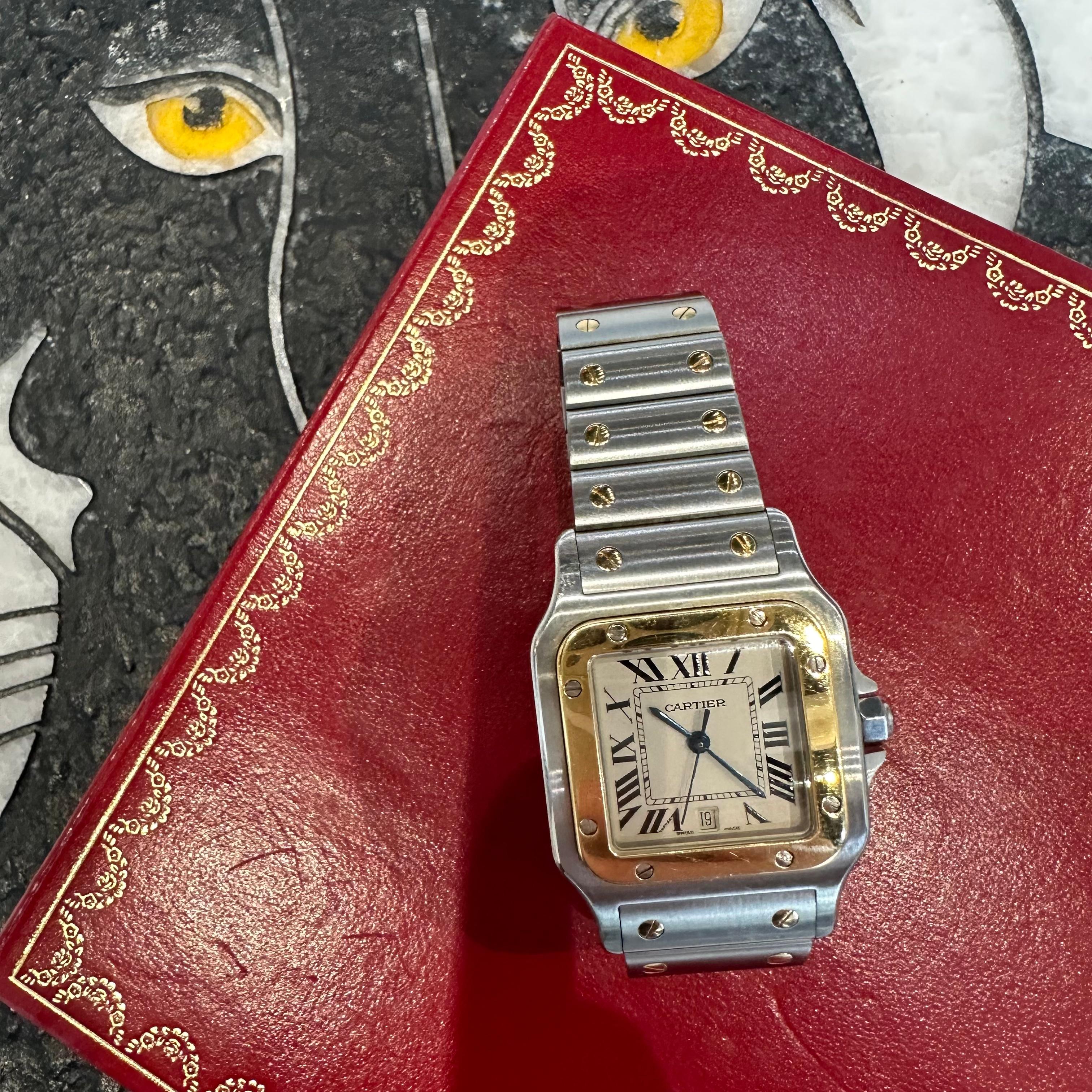Brand: Cartier

Model: Santos Galbee

Ref: W20011C4/1566

Movement: Quartz

Bracelet Fit : 6.75 inches

Case Size: 29 mm x 29mm 

Material: Stainless Steel ​and 18k Yellow Gold

Year: 2006 

Crown: Synthetic Blue Spinel

Dial:  White 

Includes: 24