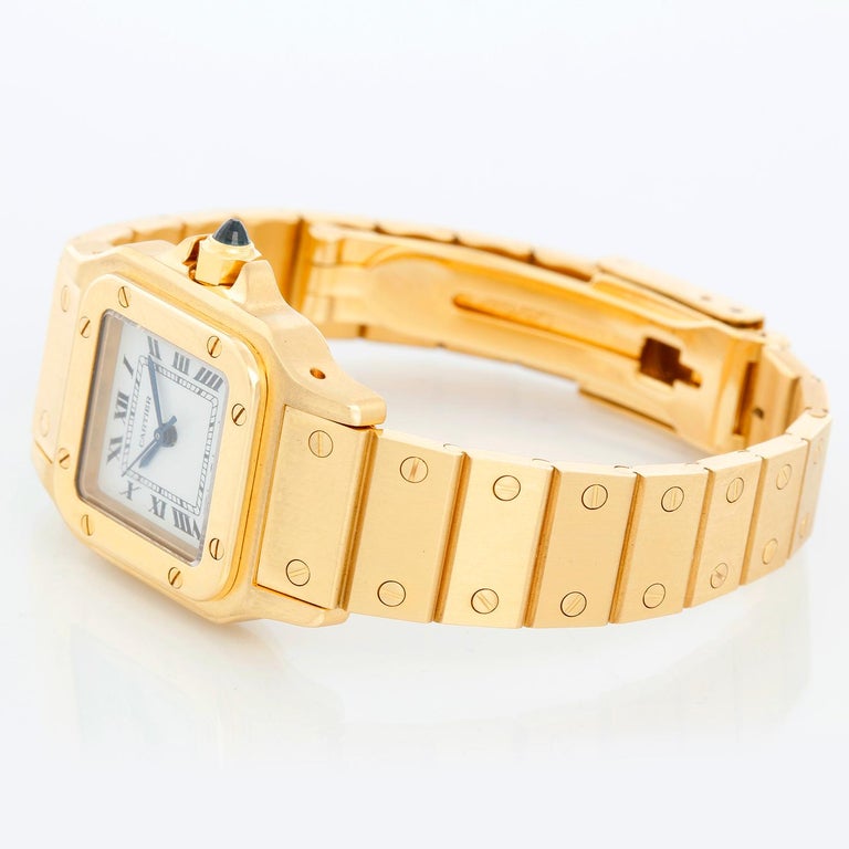 Cartier Santos Ladies 18k Yellow Gold Watch WGSA007 - Automatic. 18k yellow gold case (25 mm x 36 mm ). White dial with black Roman numerals and date at 3 o'clock. 18K Yellow Gold Santos bracelet; will fit up to a 6 1/4 inch wrist. Pre-owned with