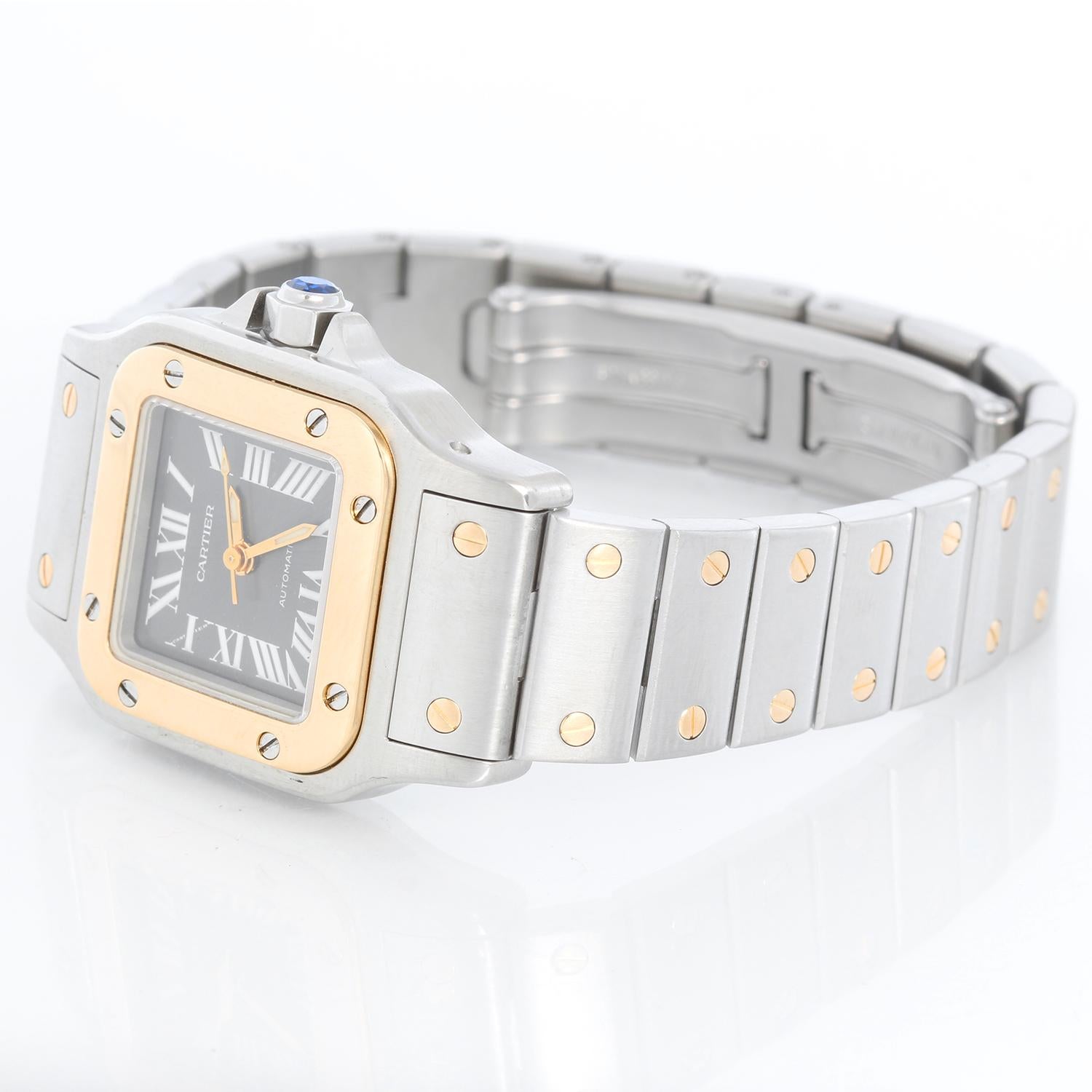 Cartier Santos Ladies 24mm Steel & Gold 2-Tone Automatic Watch 2423 - Automatic. Stainless steel case with 18k yellow gold bezel (24mm x 34mm ). Charcoal dial with luminous roman numerals. Stainless steel bracelet with gold accents. Pre-owned with