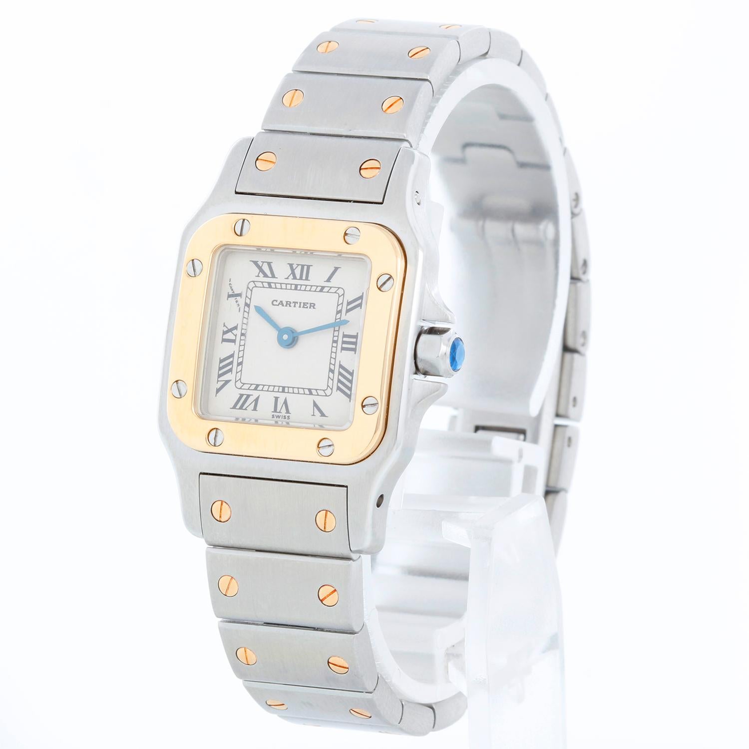 Cartier Santos Ladies 24mm Steel & Gold 2-Tone Watch - Quartz. Stainless steel case with 18k yellow gold bezel (24mm x 34mm ). White dial with roman numerals. Stainless steel bracelet with gold accents (will fit apx. 6-1/4-in. wrist). Pre-owned with