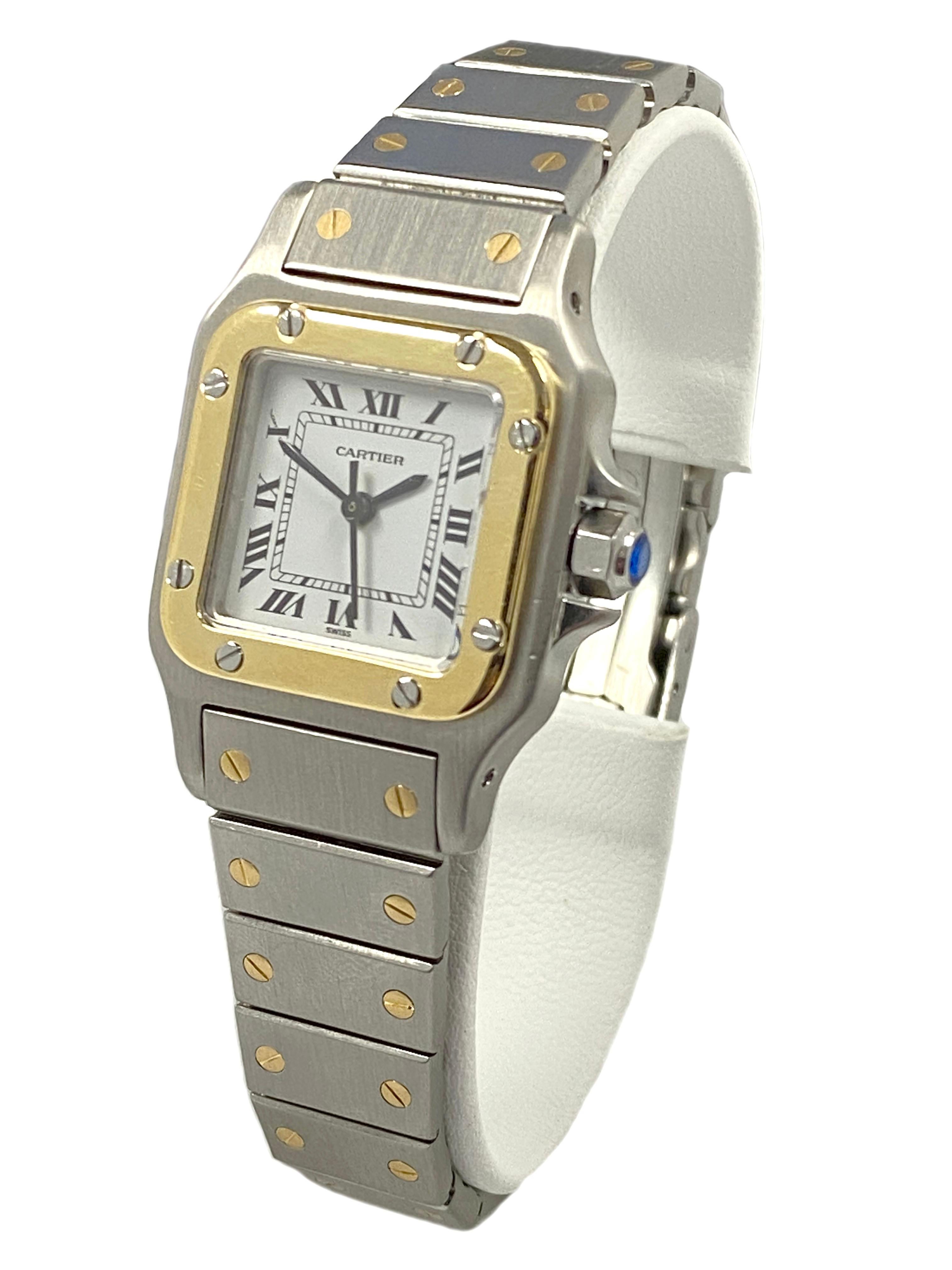 Circa 2005 Cartier Santos Ladies Wrist Watch, 34 X 24 MM Stainless Steel case with 18K yellow Gold Bezel. Automatic, Self Winding Movement, White Dial with Black Roman Numerals and a sapphire crown. 1/2 inch wide Stainless Steel and 18K Yellow Gold