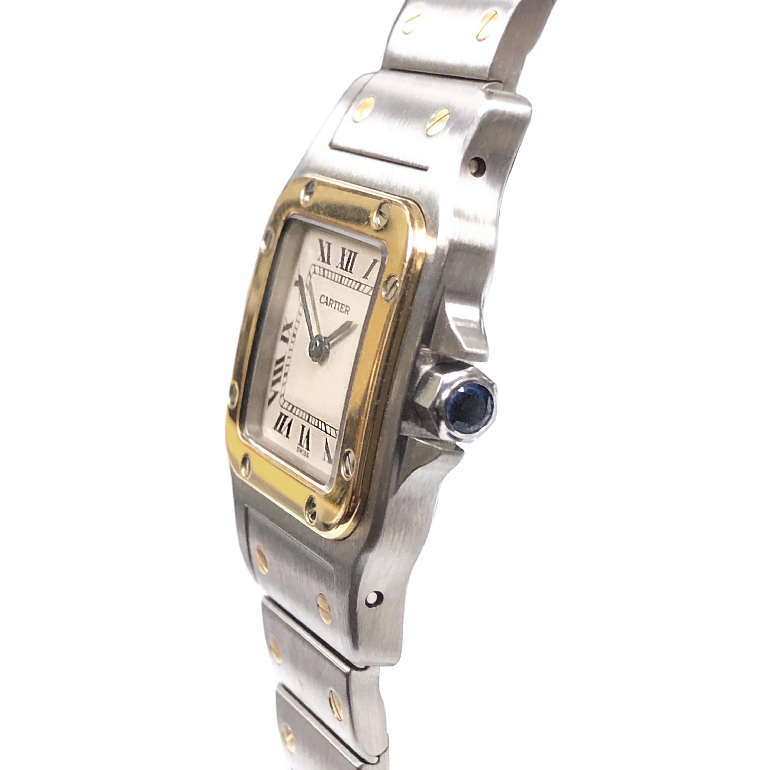 Circa 2000 Cartier Santos Ladies Wrist watch, 35 X 33 MM Stainless Steel and 18K Yellow Gold Water Resistant case. Quartz Movement, White Dial with Black Roman Numerals and a Sapphire Crown. 1/2 inch wide Steel and 18K bracelet with Deployment