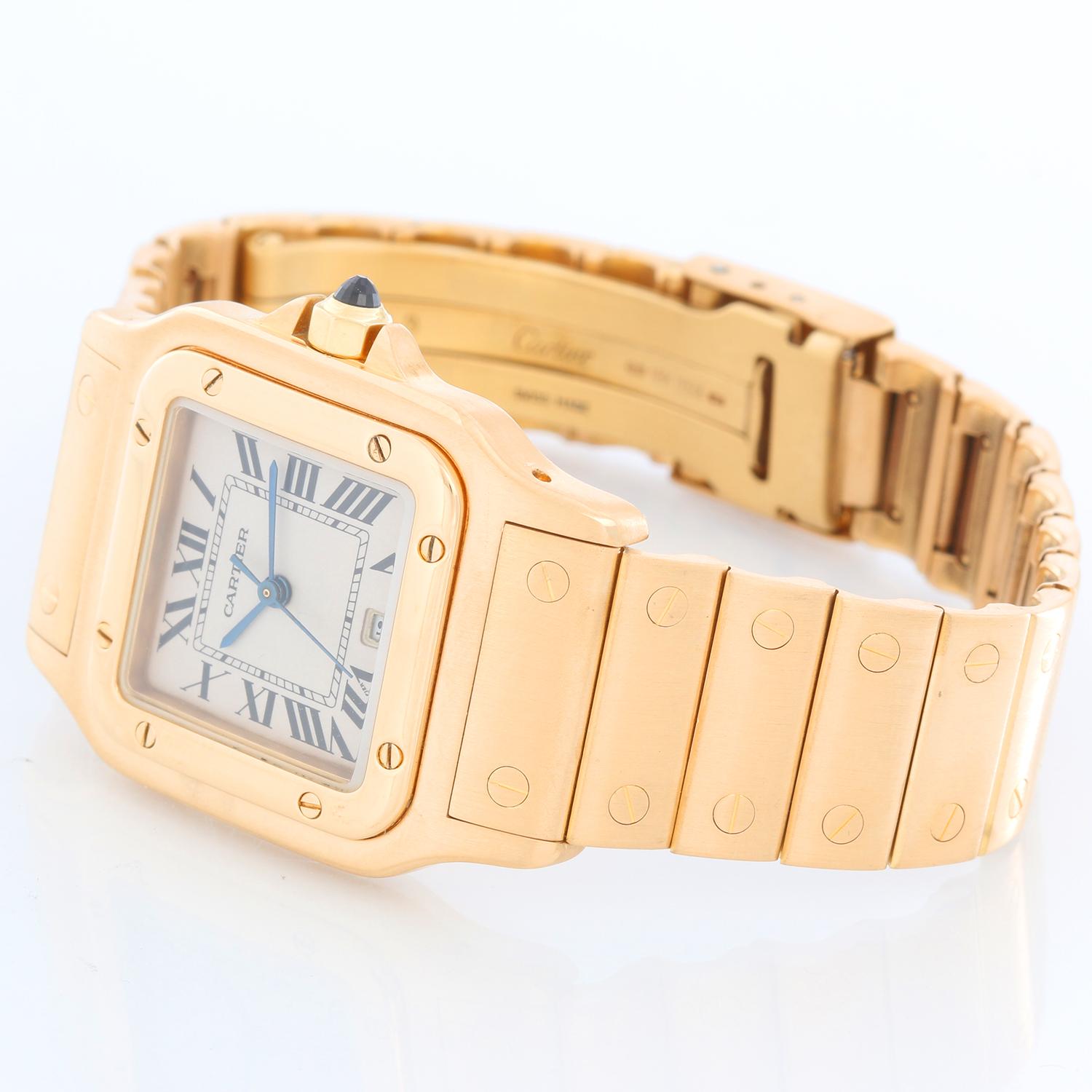 Cartier Santos Men's 18k Yellow Gold Watch W20010C5 - Quartz. 18k yellow gold case (29mm x 41mm). White dial with black Roman numerals and date at 6 o'clock. 18k yellow gold Santos bracelet with deployant clasp. Pre-owned with Cartier box and books. 