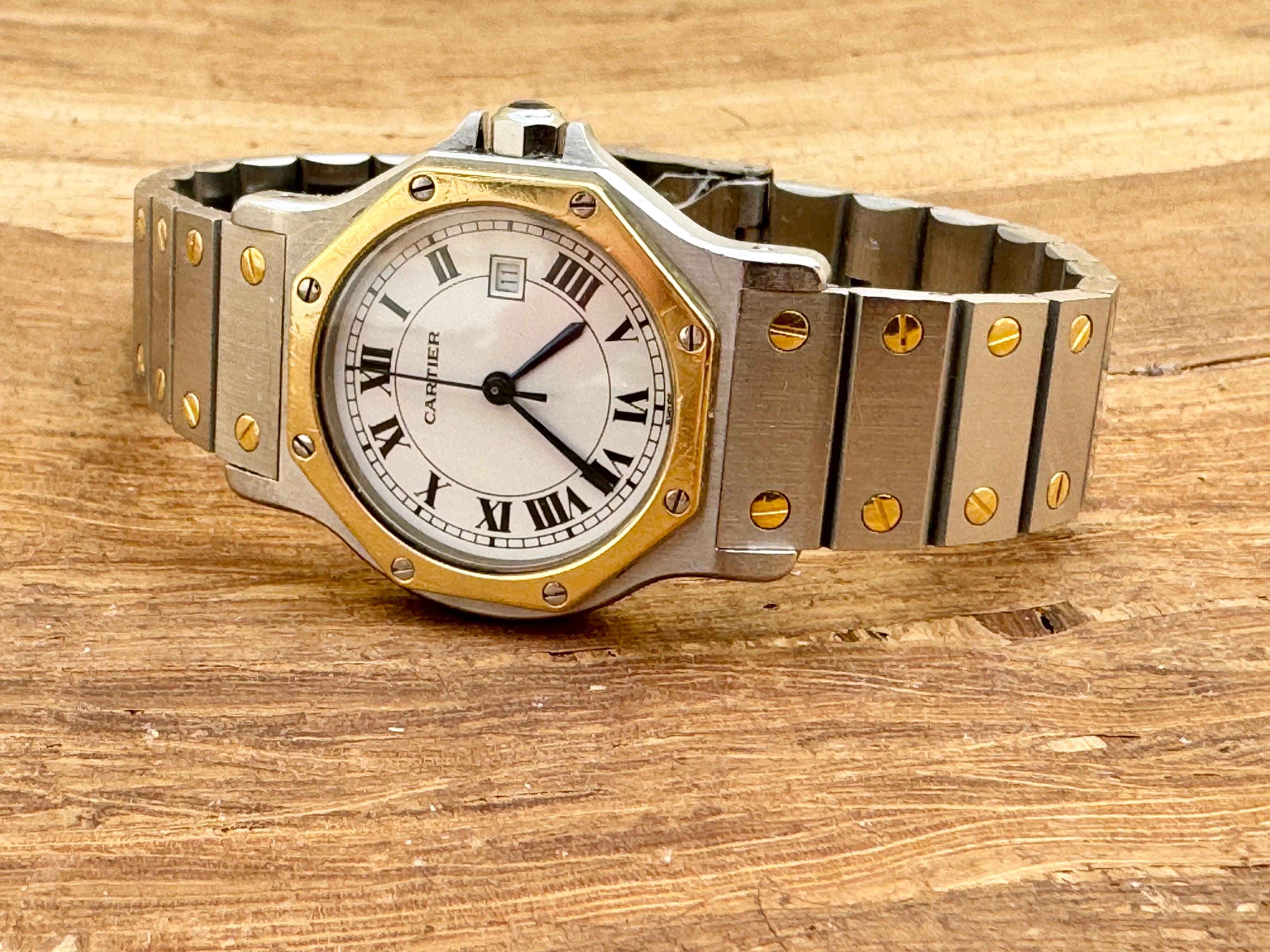 Marke : Cartier

Modell: Santos Achteck

Aktenzeichen: 29662

Land der Herstellung: Schweiz

Uhrwerk: Automatik

MATERIAL des Gehäuses: Rostfreier Stahl/Gold

Maße: 30mm Durchmesser (ohne Krone)

Band Typ : Edelstahl/Gold mit markierter
