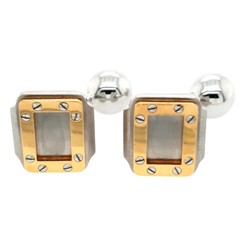 18kt Yellow Gold Cartier Santos Oretacier Rectangular Cufflinks Steel

Pair of Cartier Santos Oretacier 18K and steel cufflinks comprised of a rectangular face topped with an 18K border with screw motif, curved steel shaft and steel ball. Marked and