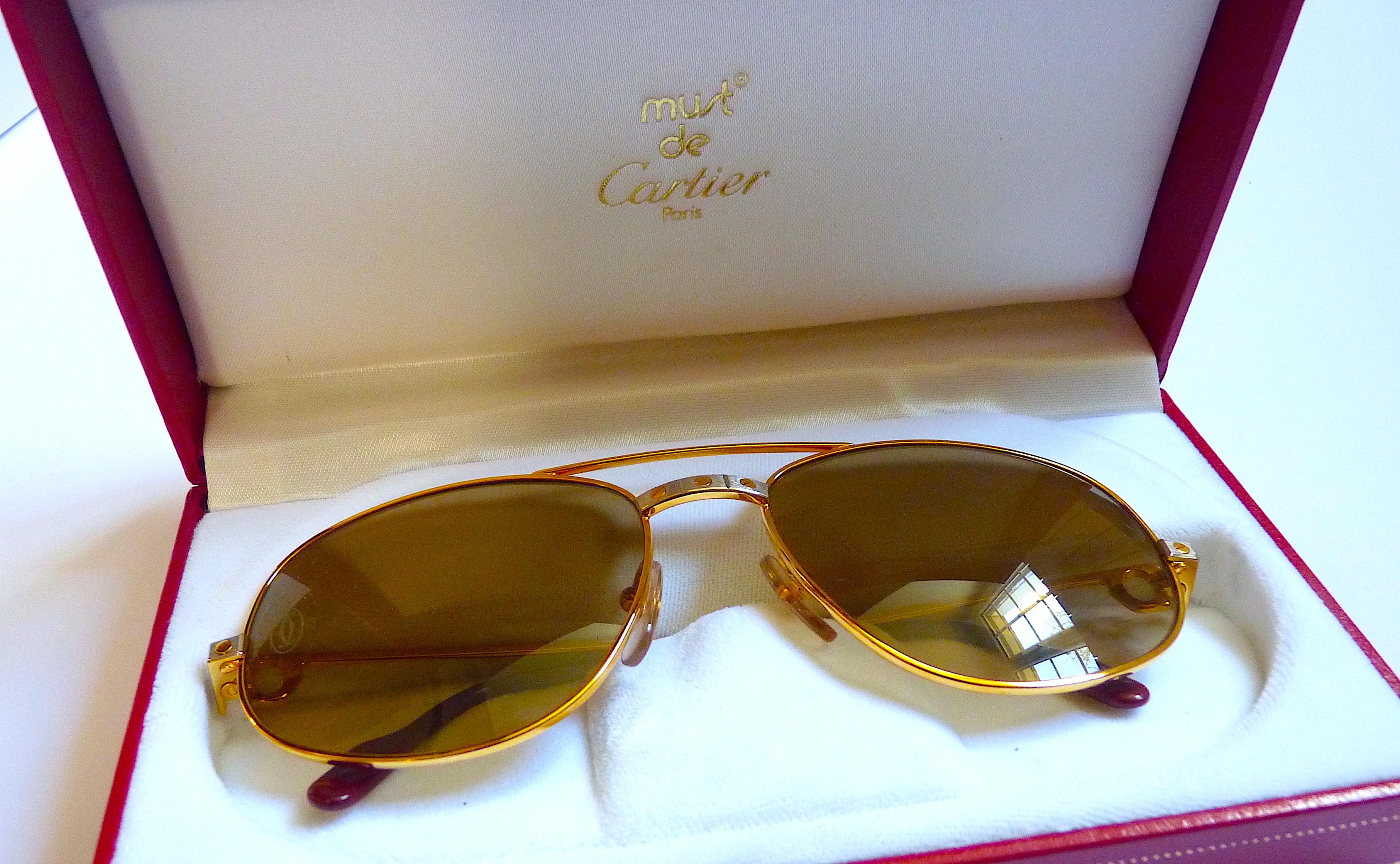 These CARTIER SANTOS Sunglasses are iconic from the 1980's, with Original Packaging, Vintage but never worn

New of Stock, Unworn and Pristine Condition !

Will come with all accessories shown on the pics : authenticity certificate, leather case,