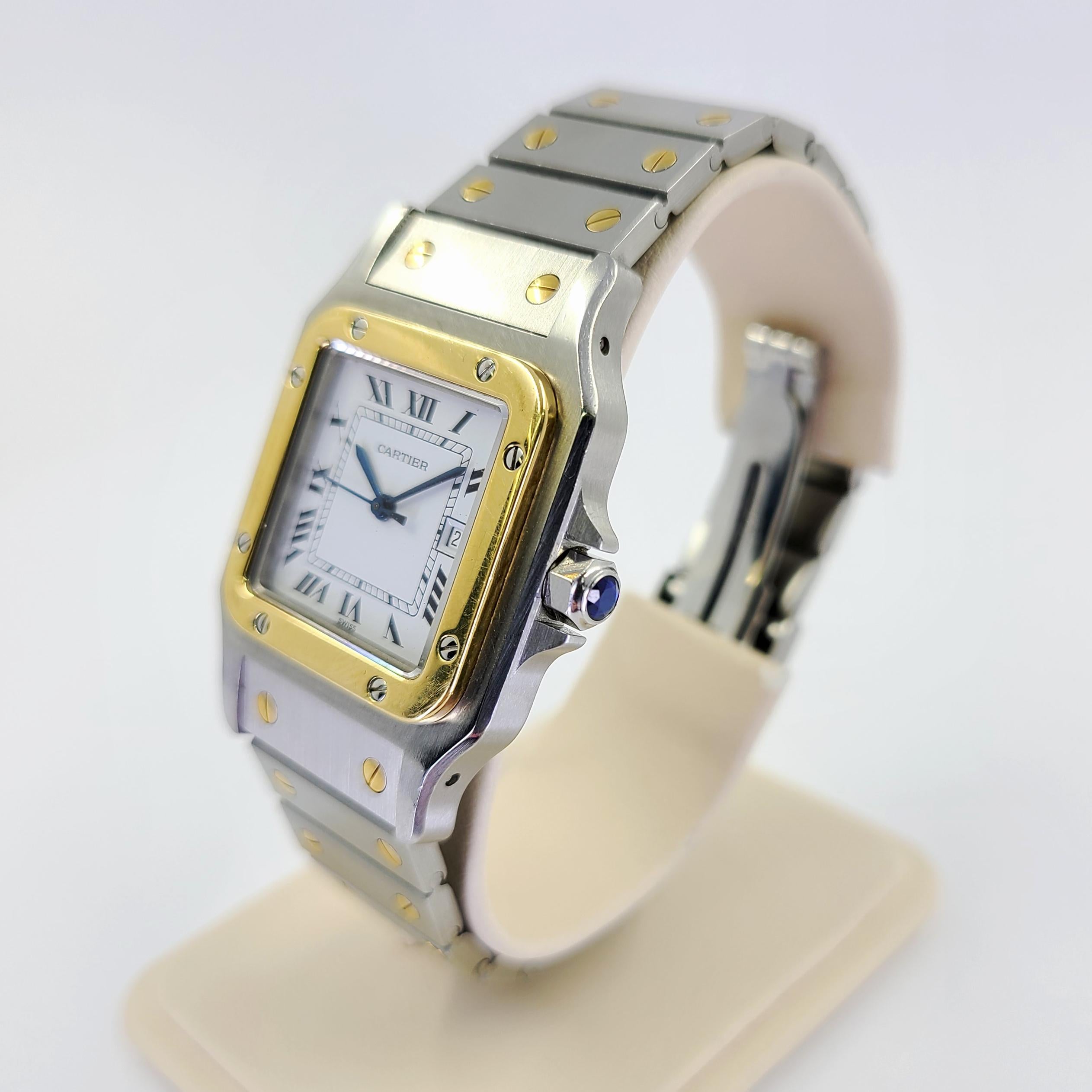 Pre-Owned Cartier Santos 18 Karat Yellow Gold & Steel Automatic Watch On Bracelet. 29mm Midsize Case With White Roman Dial. Includes 1 Year Timekeeping Warranty.
