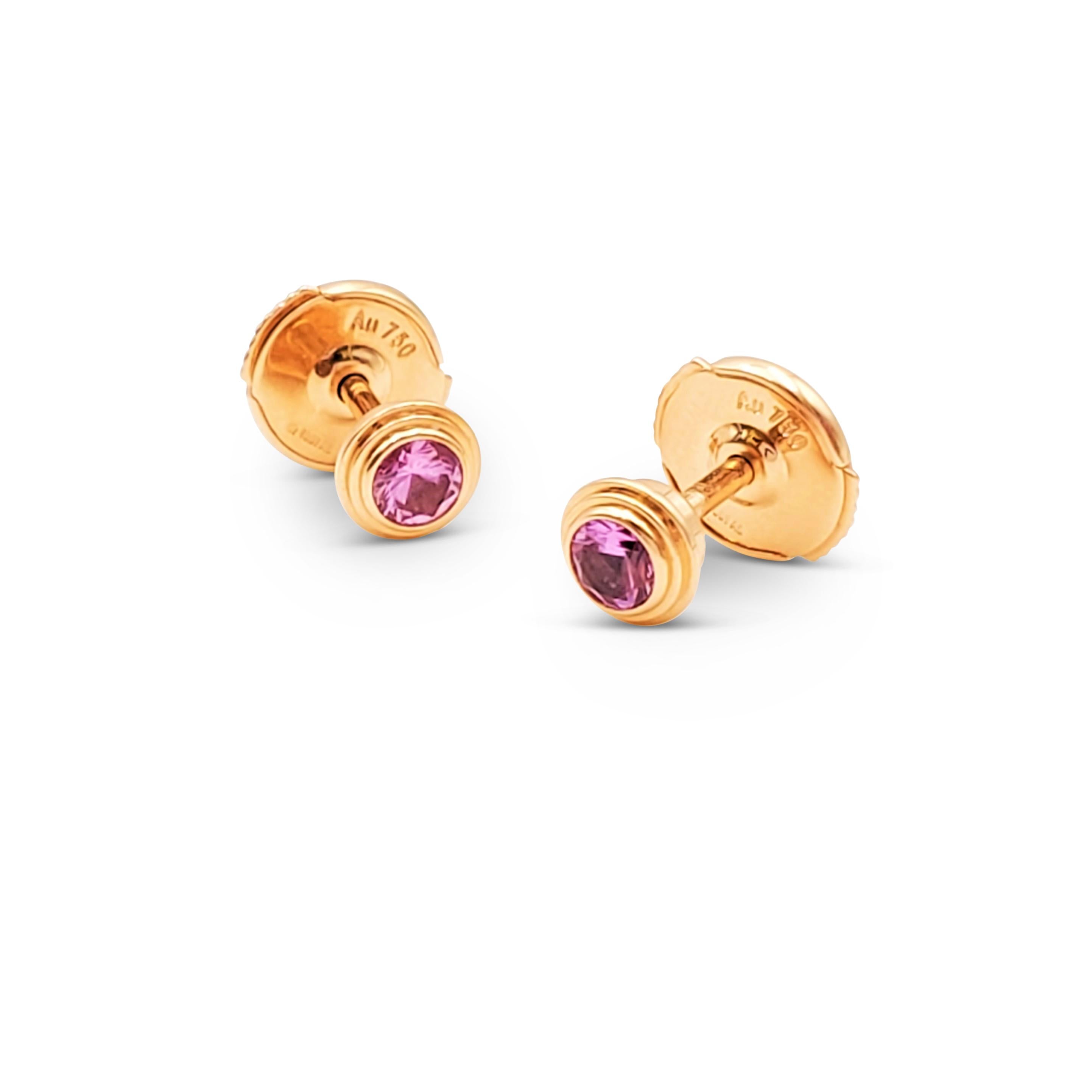 Authentic Cartier 'Saphirs Légers de Cartier' stud earrings crafted in 18 karat rose gold. Each earring features a vibrant pink sapphire stone held within a stacked bezel mounting. Signed Cartier, Au750, with serial number. The earrings are