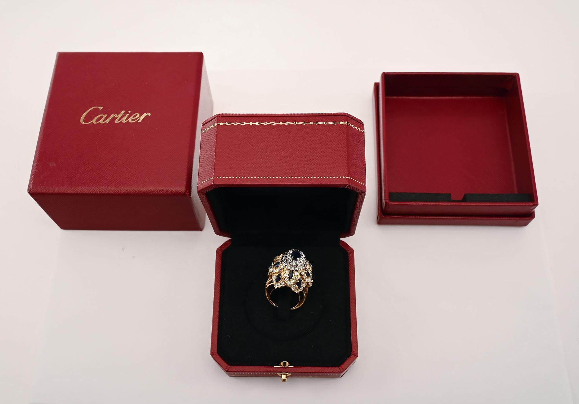 Questo anello da cocktail con zaffiro e diamanti di Cartier è un gioiello.
Ha 104 diamanti di colore G e qualità VS. Il loro peso è di 1 75 carati. Tredici zaffiri naturali pesano 2 carati. L'anello viene venduto nella scatola originale Cartier.