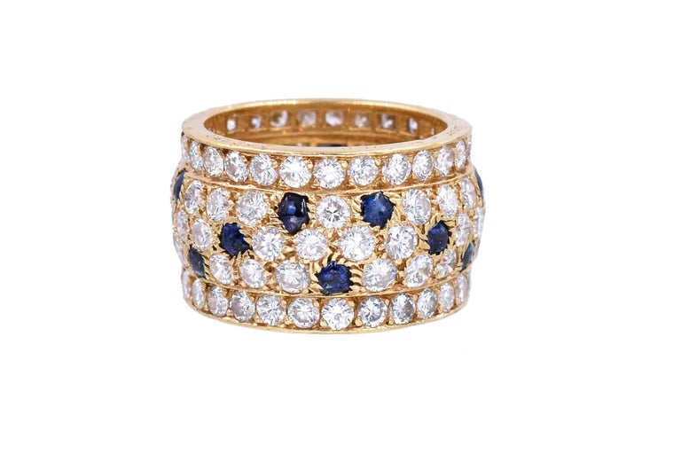  Diamond and sapphire ‘Panther’ ring, Cartier, France. The band ring set with round diamonds weighing approximately 5.60 carats, with buff-top sapphire accents, 
Ring size is 6.1/4
Signed Cartier, and # 609476, with French assay and maker's marks.
