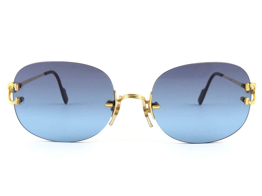 New Cartier Serrano unique rimless special edition sunglasses with blue gradient (uv protection) lenses.  Frame with the front and sides in special edition gold. All hallmarks. Cartier gold signs on the ear paddles.  These are like a pair of jewels