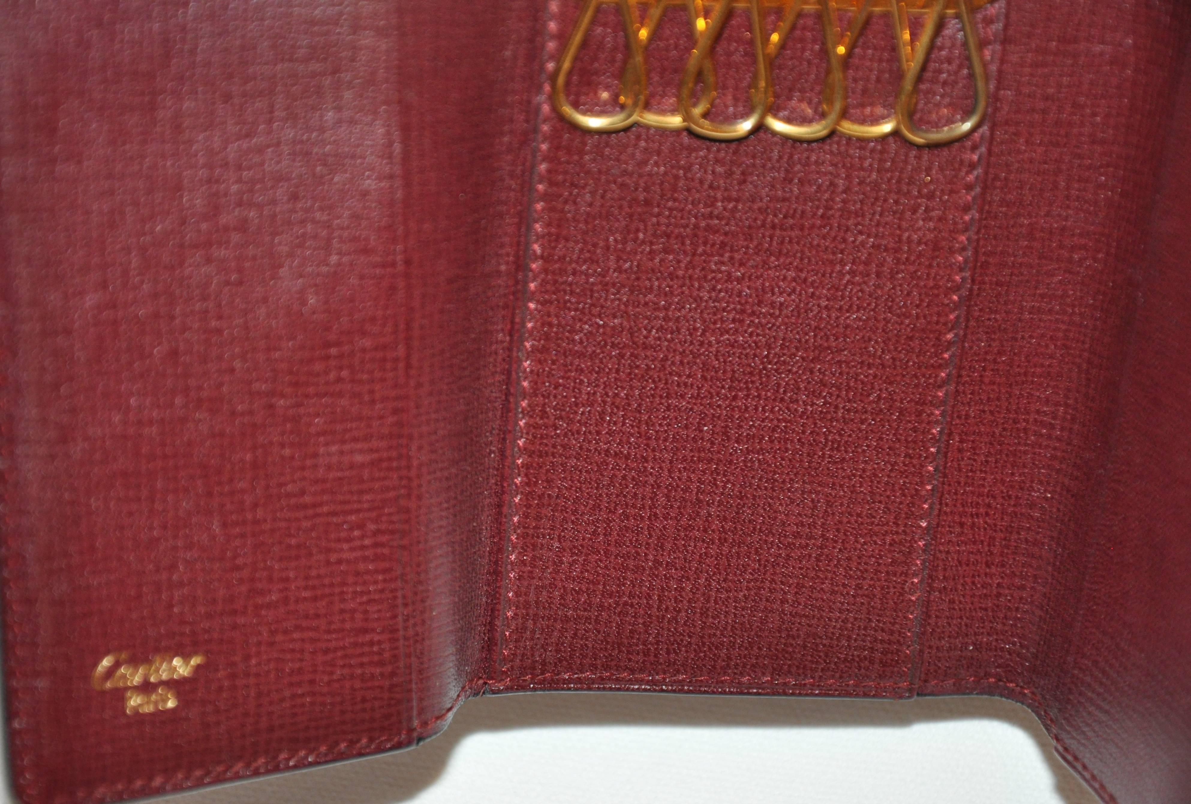 Cartier Signatur Burgunderfarbener Schlüsselanhänger aus strukturiertem Kalbsleder mit goldenen Akzenten (Braun) im Angebot