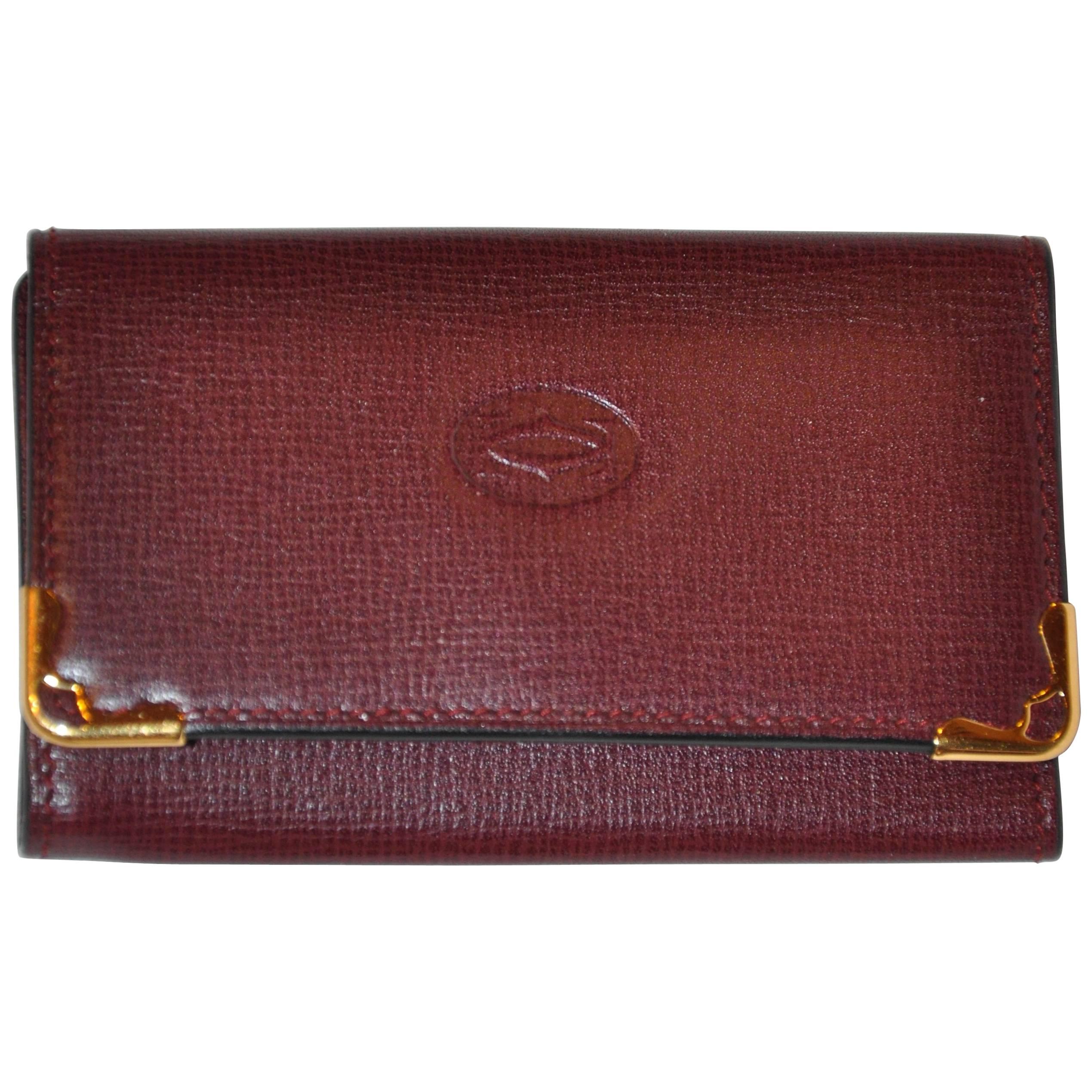 Porte-clés caractéristique Cartier en cuir de veau texturé bordeaux avec accents dorés
