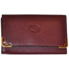 Porte-clés caractéristique Cartier en cuir de veau texturé bordeaux avec accents dorés