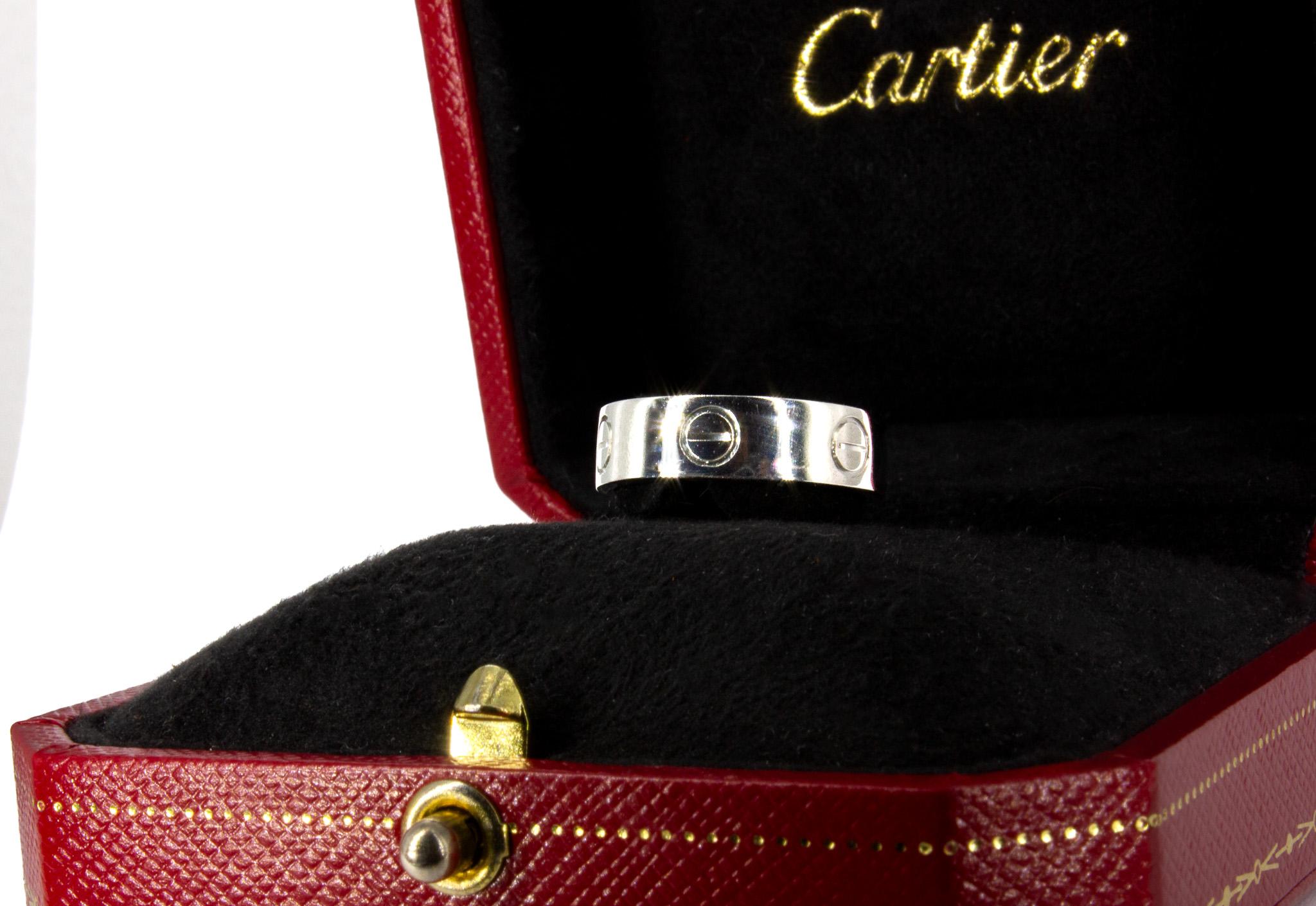 The iconic Cartier LOVE Ring is a timeless symbol of commitment and elegance. Expertly crafted in platinum, this ring features the Cartier makers mark, serial number and hallmarks, and comes complete with its original Cartier box, pouch and