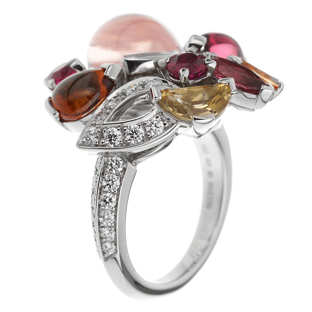 A fabulous Cartier cocktail ring showcasing pear-shaped rose quartz accented by rubies, yellow sapphires, pink tourmalines, orange garnets and tiny round diamonds, mounted in 18k white gold, signed Cartier and numbered. The ring measures a size 4