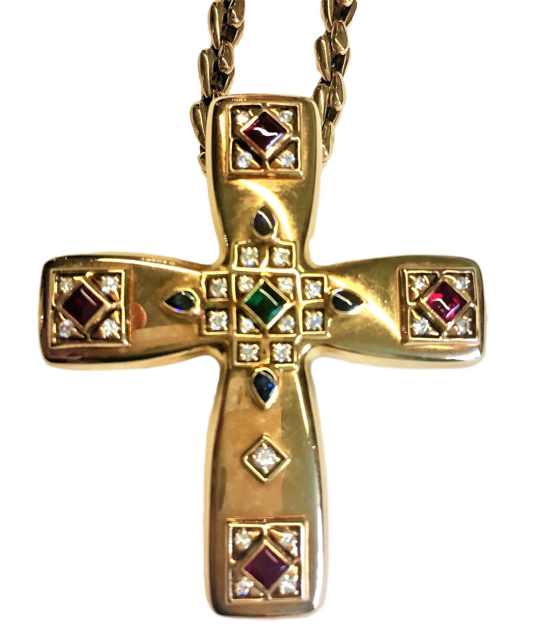 Cross clip/pendant created by Cartier in 1993. Byzantine style inspired by Louis Cartier's travels to Russia in the early 20th century. 
Pendant 18 karat yellow gold studded with rubies, sapphires, emerald and diamonds. 
Signed Cartier. Numbered.