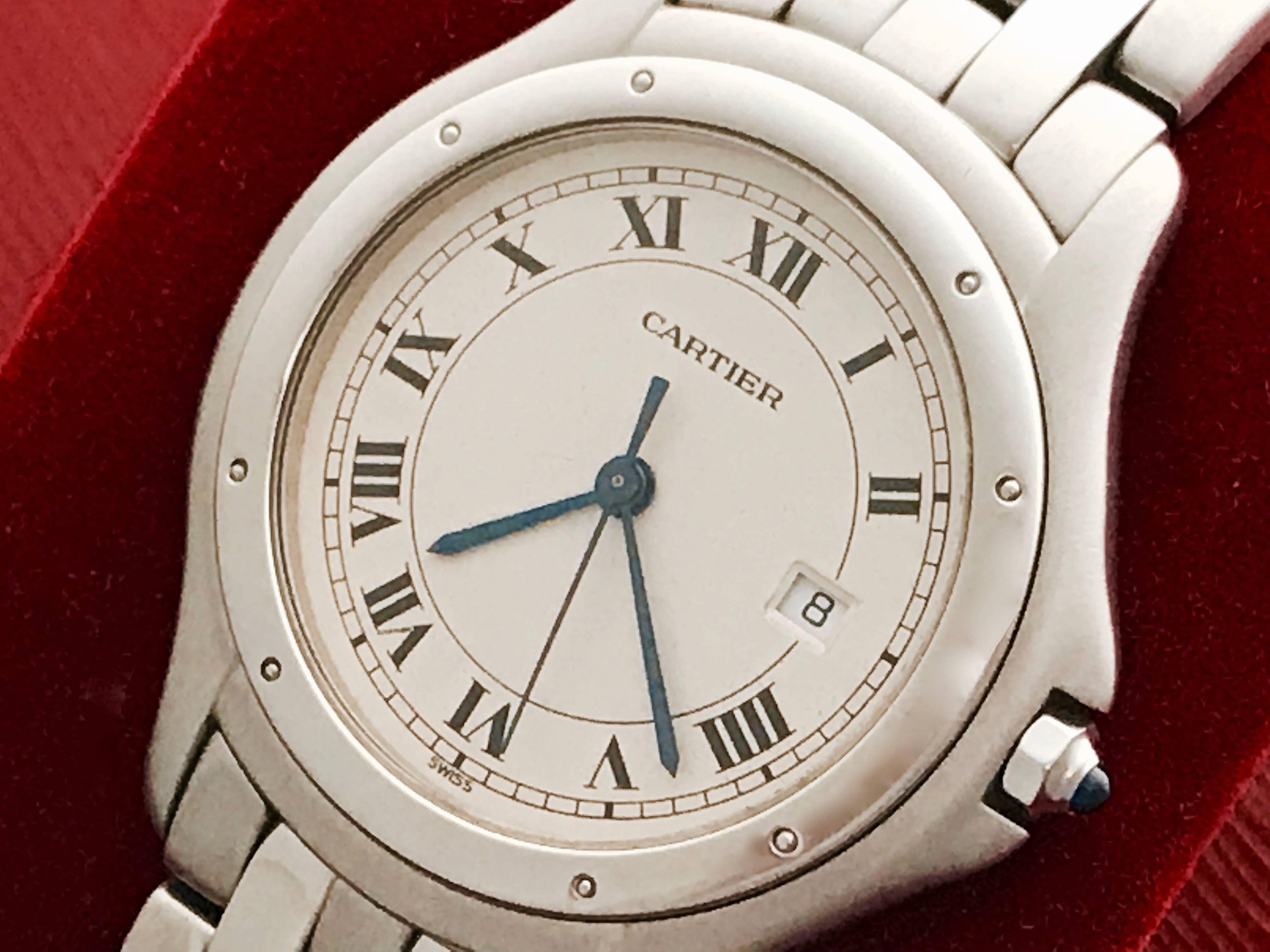 Cartier Cougar Midsize Stainless Steel Quartz Wrist Watch.  Certified pre-owned and ready to ship.  Quartz movement with date.  Stainless Steel round case (33mm dia.).  Stainless Steel Cartier bracelet with deployant clasp. Off-White Dial with black