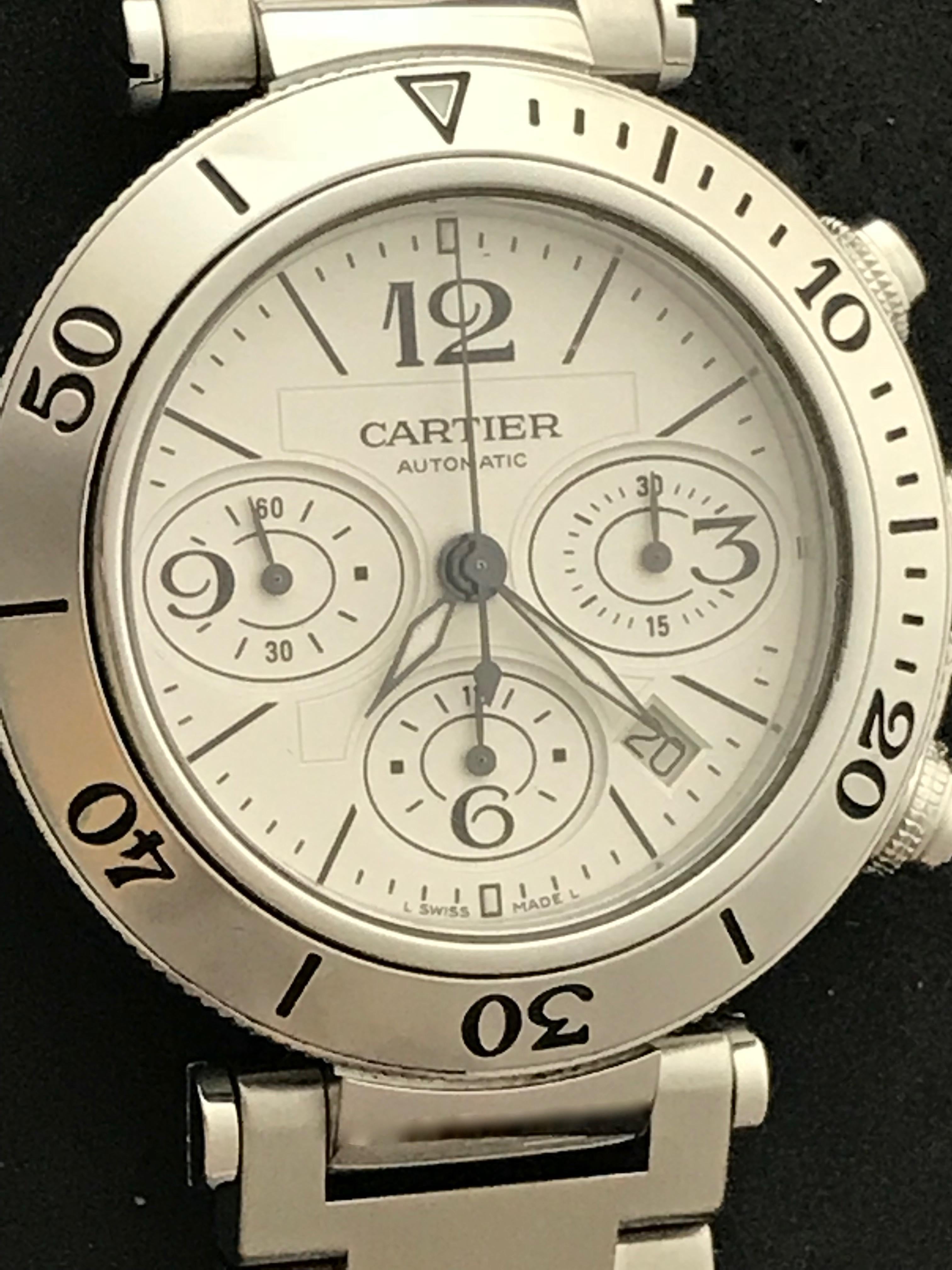 As New Cartier Pasha Mens Seatimer Wristwatch, Automatic Winding with Date. Model W31089M7. Stainless Steel case with rotating bezel (41.5mm dia.)  Stainless Steel Pasha bracelet with deployant clasp. Silvered Dial with black hour markers and black
