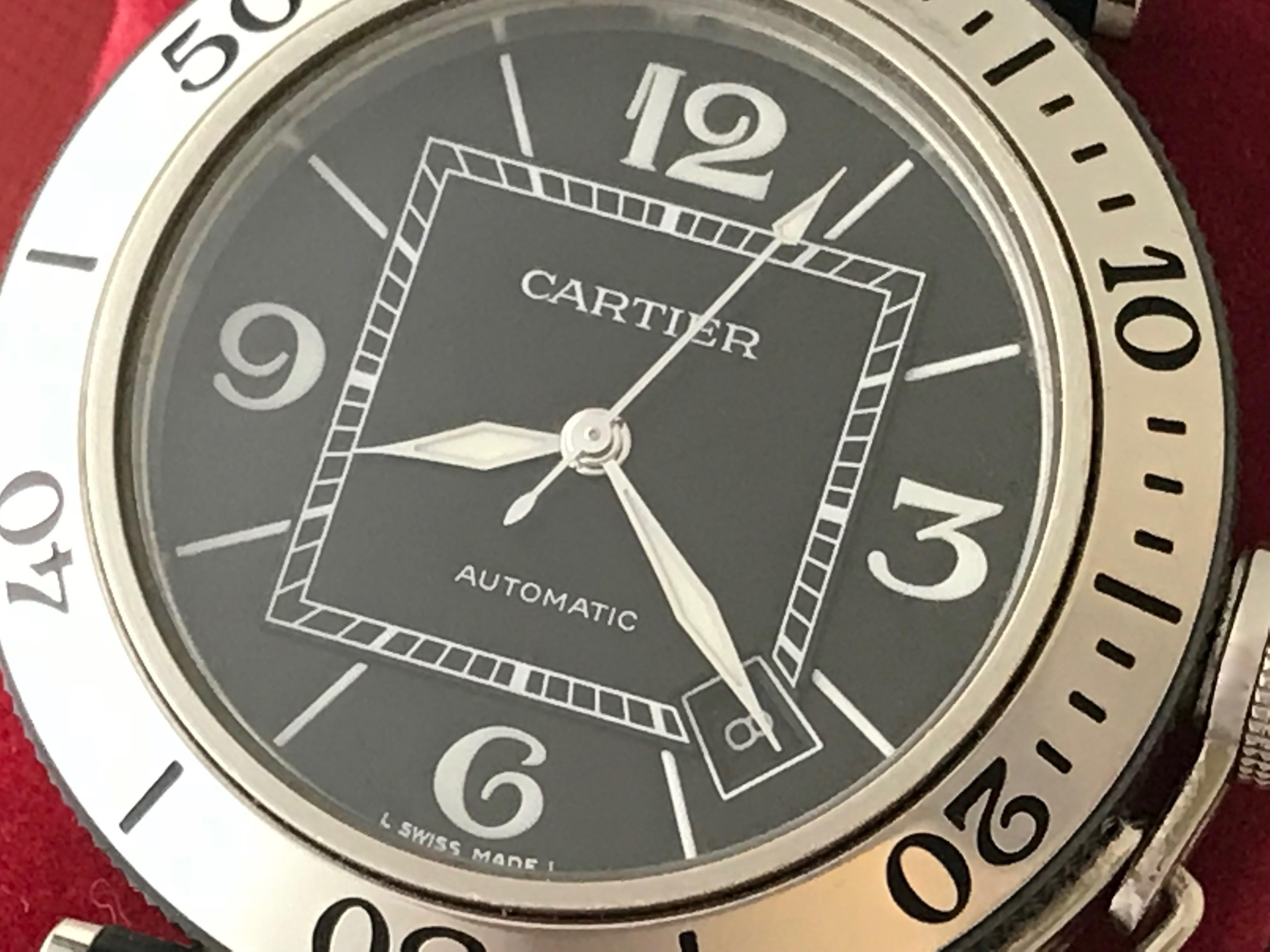 As New Cartier Pasha Mens Seatimer Wristwatch, Automatic Winding with Date. Model W31077U2. Stainless Steel case with rotating bezel (40 mm dia.)  Stainless Steel and Rubber Pasha bracelet with deployant clasp. Black Dial with luminous hour markers