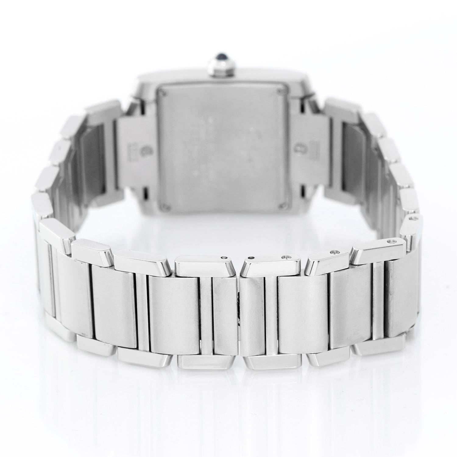 Cartier stainless steel Tank Francaise midsize wristwatch, Ref. W51011Q3, with quartz movement. Stainless steel case (25mm x 30mm). Ivory-colored dial with black Roman numerals, date at 3 o'clock. Stainless steel Cartier bracelet with deployant