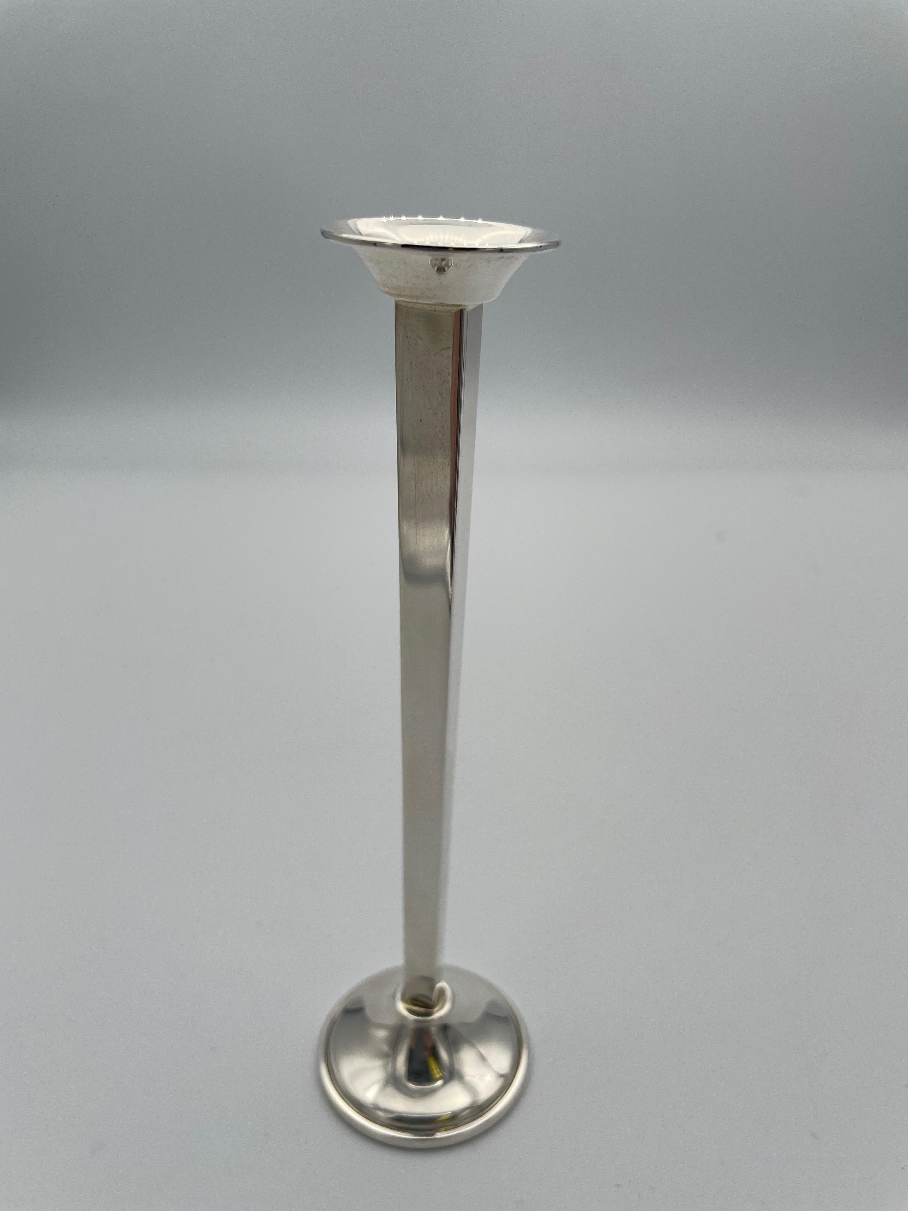 A slim elegant sterling silver bud vase.  Made and signed by CARTIER.  Faceted, with flaring rim and base.  5 1/2