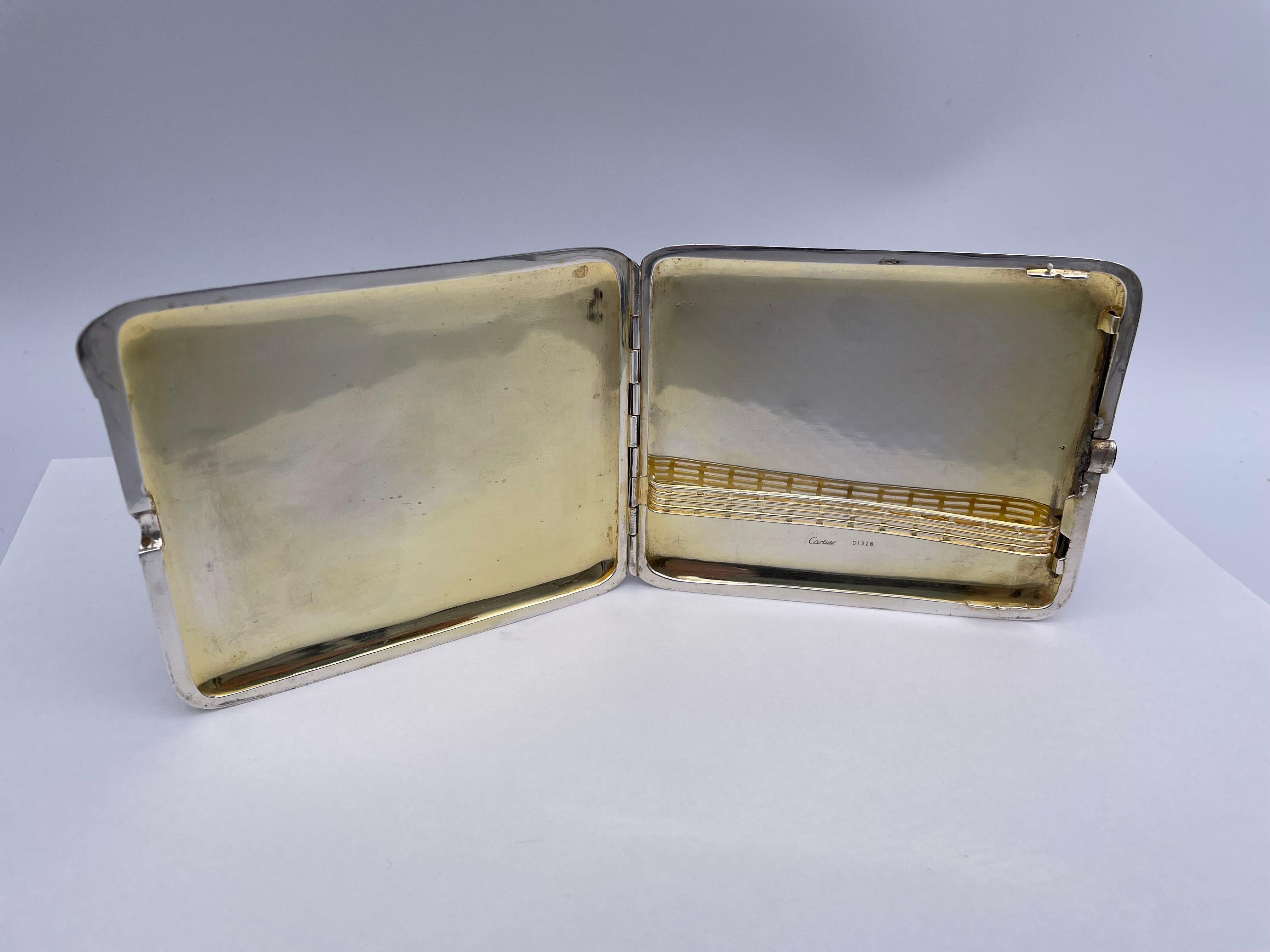 A most handsome art deco hinged case.  Made, signed and numbered by CARTIER.  Heavy gauge sterling silver, embellished by panels of 18K yellow gold.  Allover engraved diamond pattern.  Faceted sapphire set in the clasp.  `3 1/4