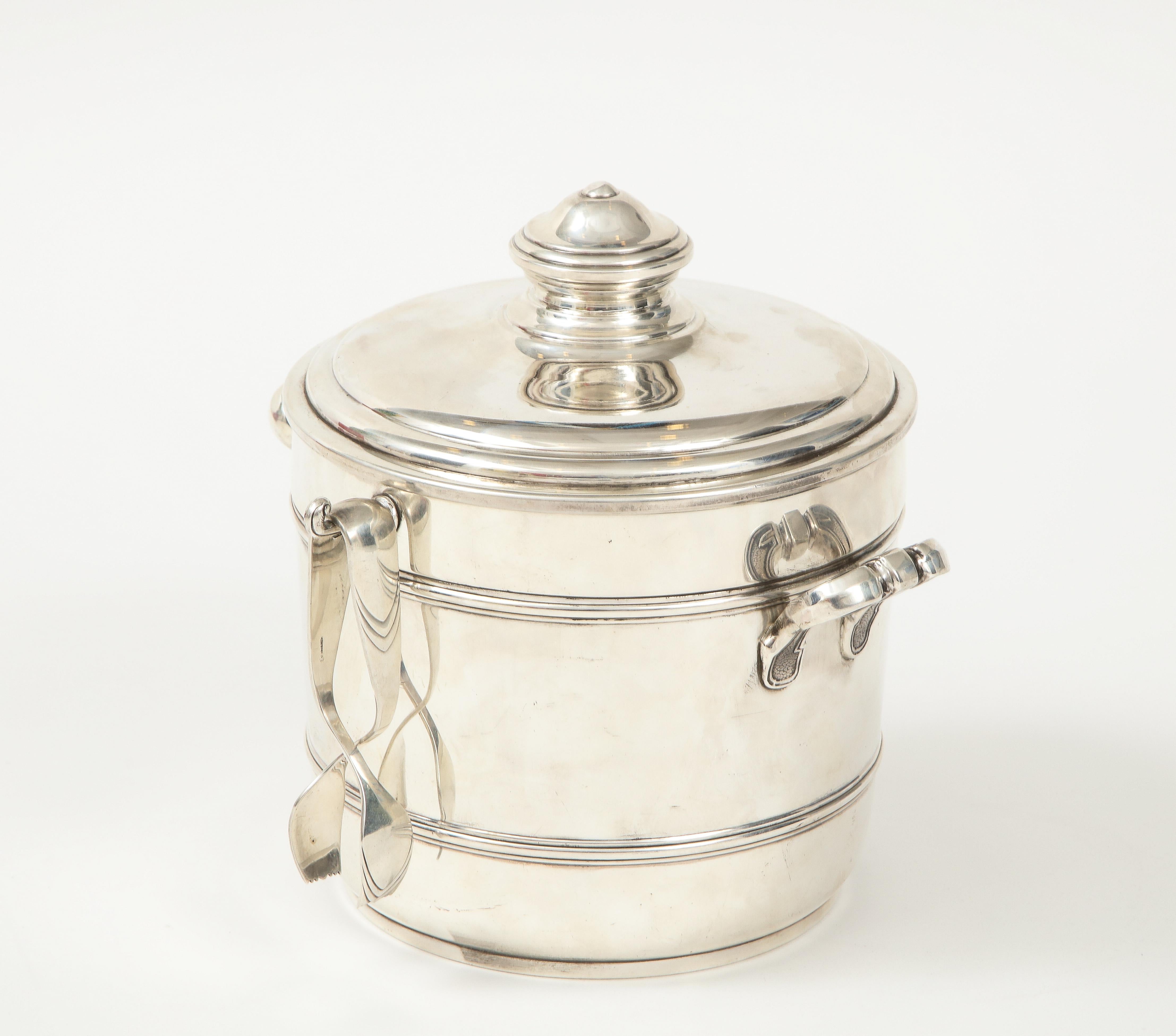 A fabulous Cartier sterling silver ice bucket with tongs with its original box. It has a perforated insulated liner that allows for moisture to escape therefore in impeccable condition.