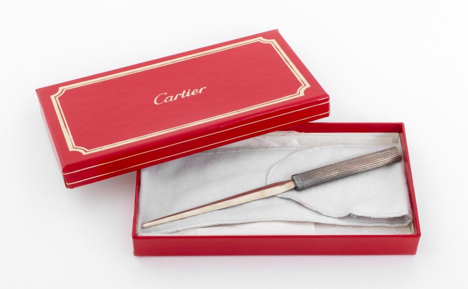 Gruppo di 12 articoli da regalo in argento sterling di Cartier, comprendente: set di tre (3) pezzi da bar composto da un apribottiglie con manico in argento e due tappi per bottiglie con l'incisione 