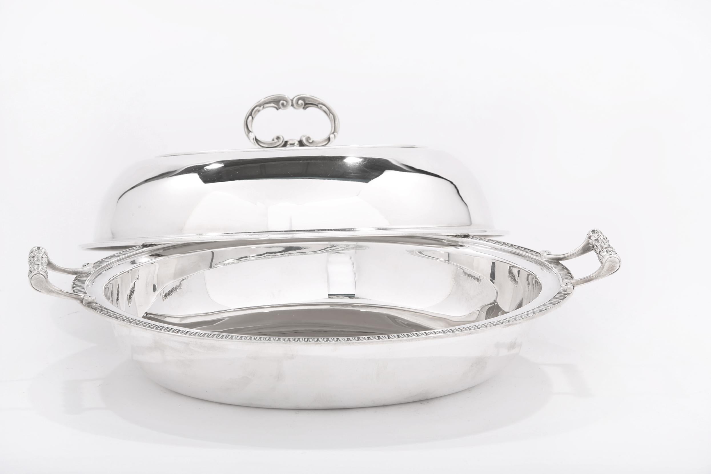 Cartier sterling silver tableware covered vegetable dish with exterior egg and dart rim design & side handles. The covered bowl is in great condition. Minor wear. Maker' mark undersigned. The bowl measure about 12.5 inches length x 9.5 inches deep x