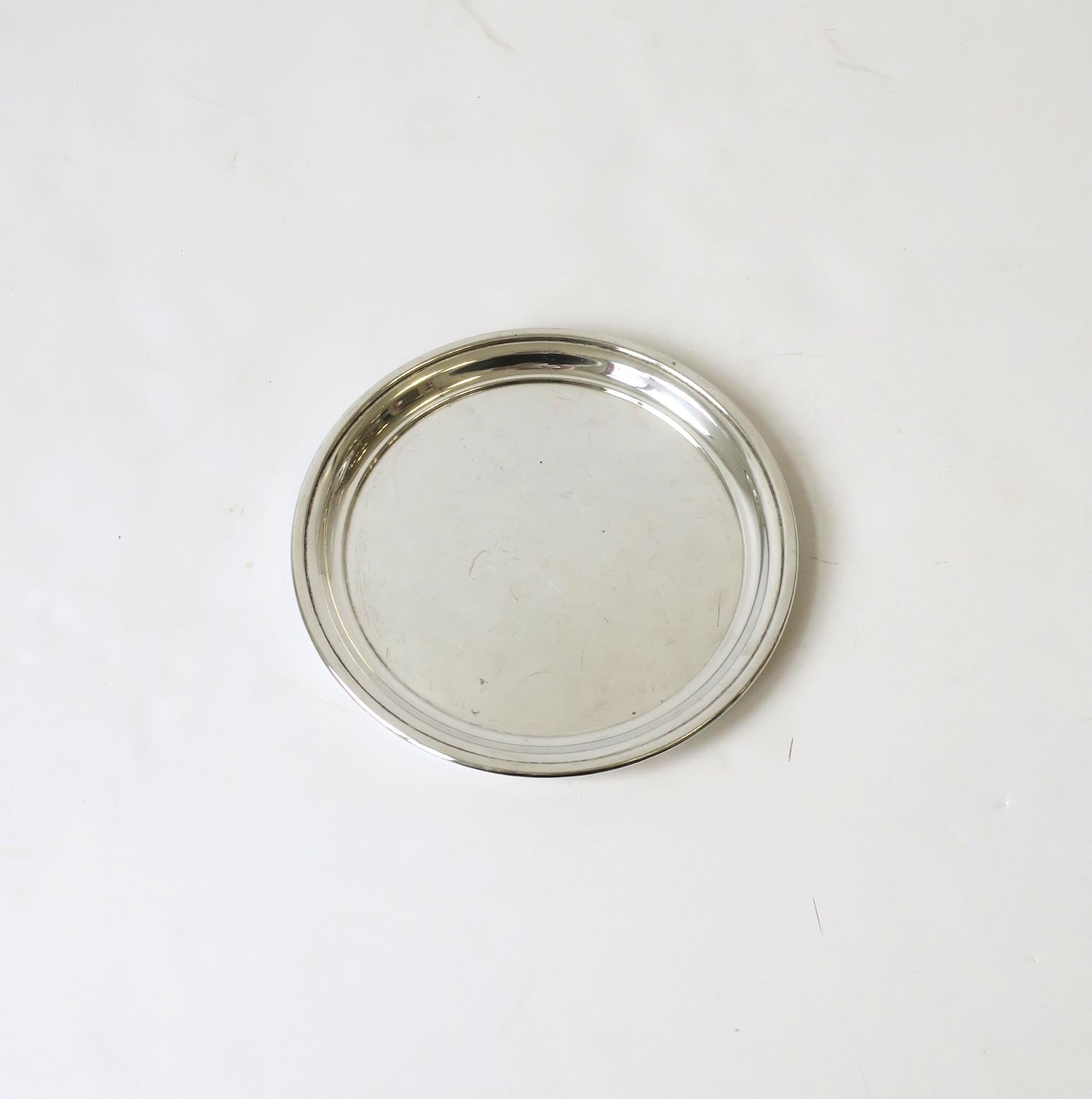 A round sterling silver tray from French luxury Maison Cartier, circa late-20th century, France. This round all sterling silvery tray is perfect to serve a cocktail or to hold jewelry on a vanity or nightstand, etc. Many uses. Piece is marked on