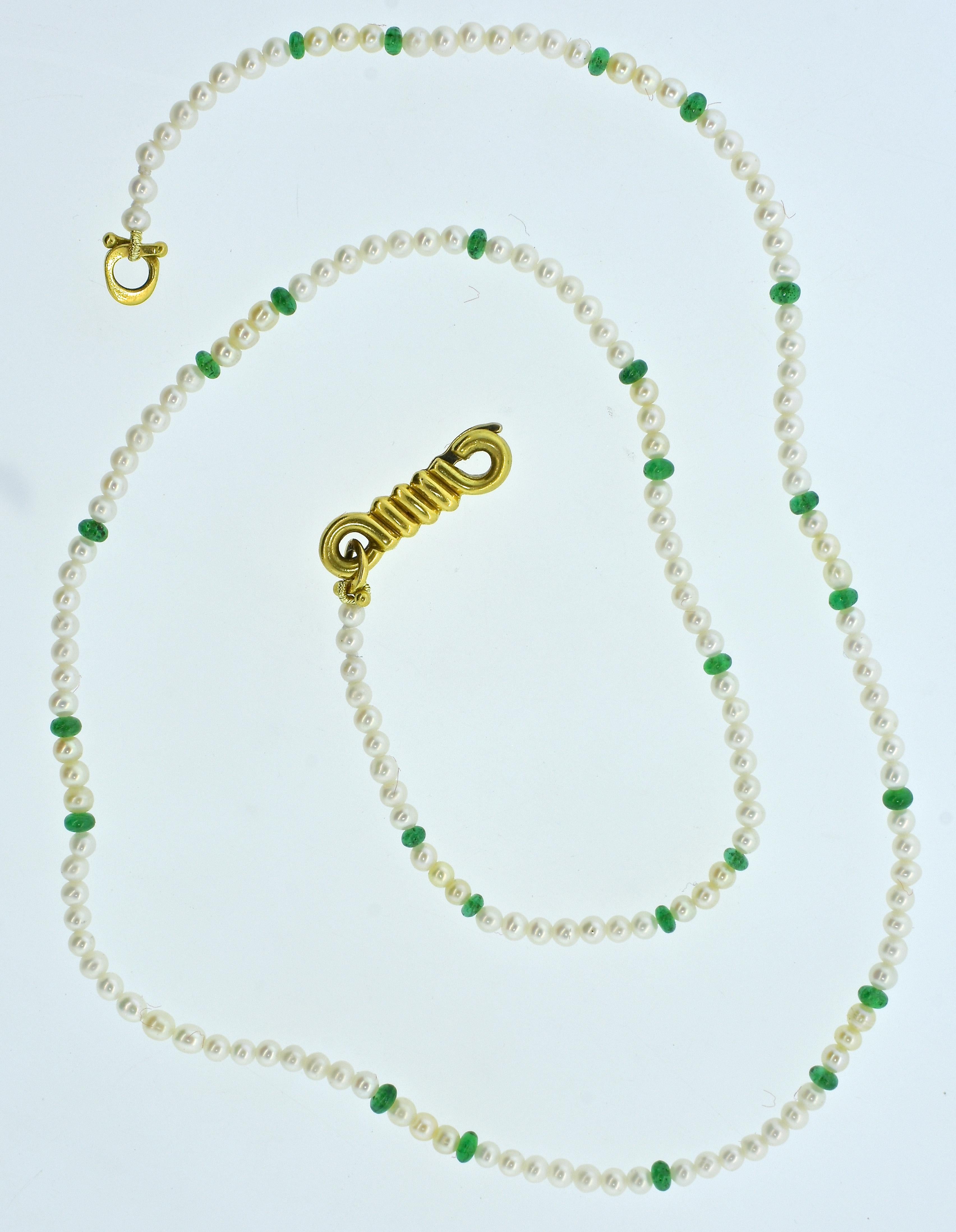Cartier strand of small natural salt water pearls interspersed with natural emerald beads.  The 18K gold clasp is signed in block letters, Cartier and 18k.  This necklace is 20.5 inches in length, the white well matched pearls which display fine