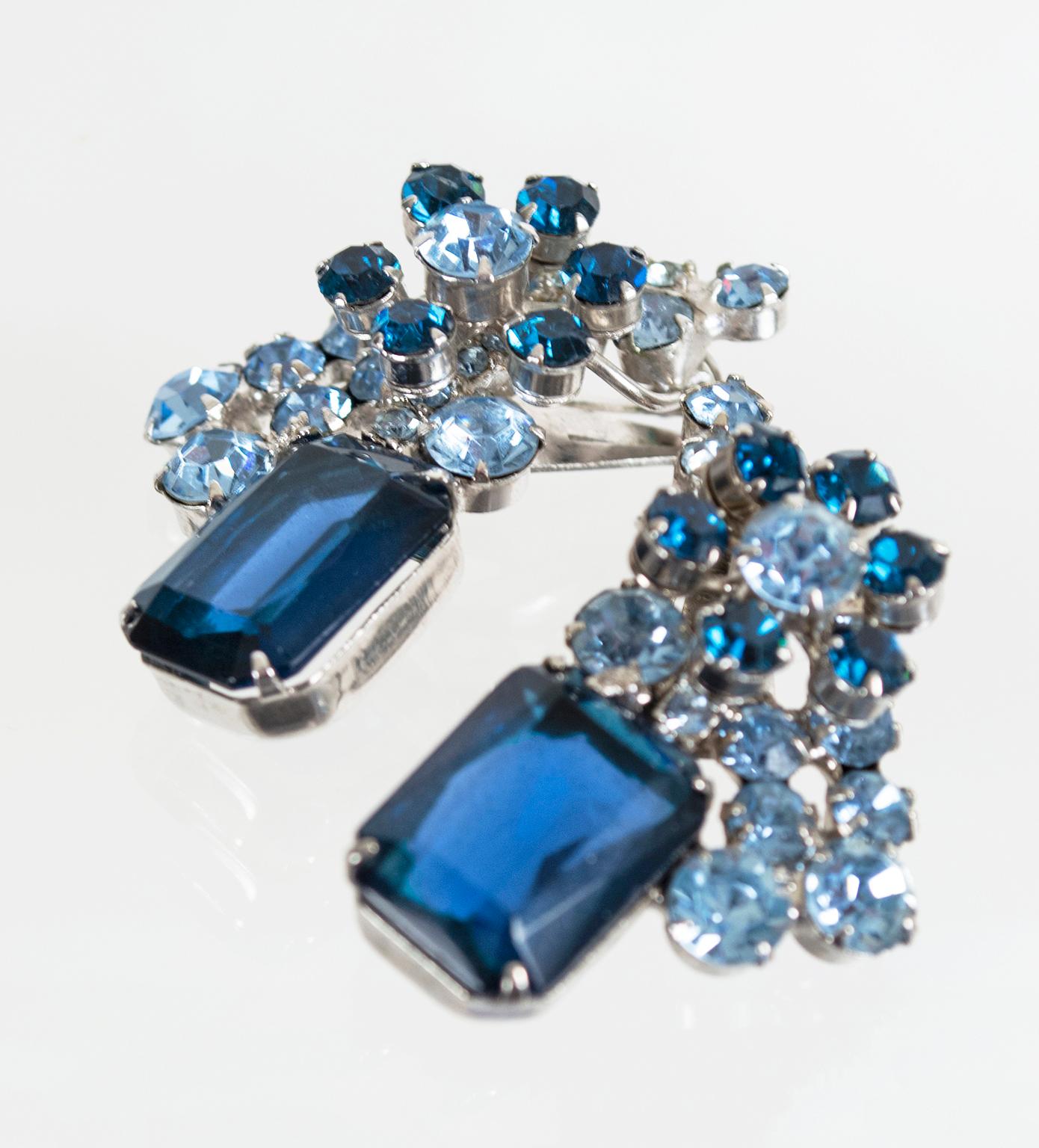 Though it is over a half century old, this exquisite earring and brooch set is as chunky, relevant and wearable as any modern costume jewelry. Fiery and brilliant, their centerpieces are their single emerald-cut crystals, which resemble Cartier