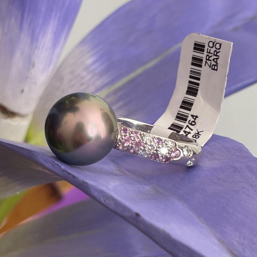 18 karat white gold Tahitian pearl ring by Cartier. The Tahitian pearl measures 12.5mm. There are 12 round brilliant cut diamonds, E color,  VS clarity, weighing an estimated 0.45 carats total and 15 pink sapphires  estimated to weigh 0.40 carats