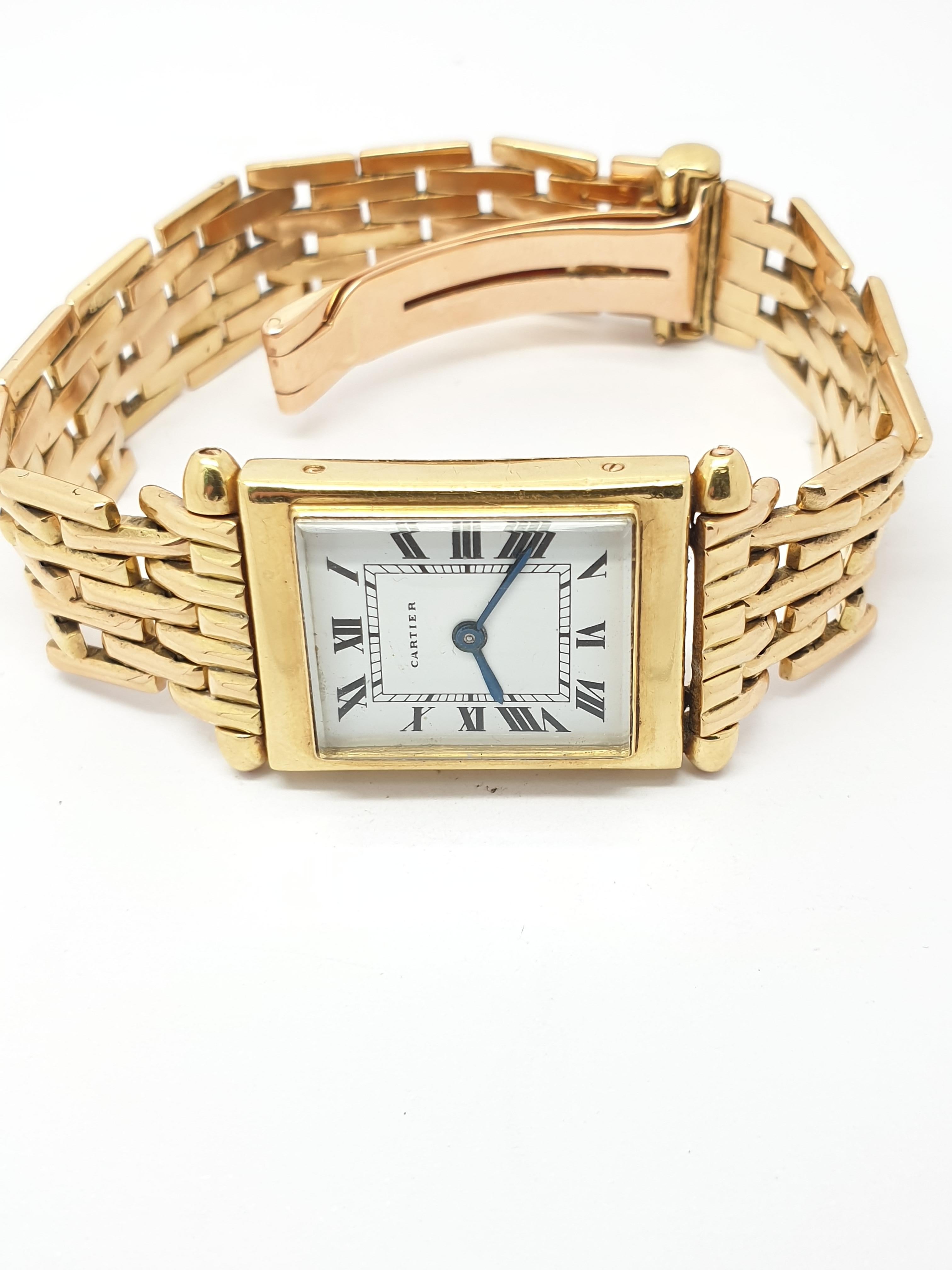 A Vintage late 1930's 18 kt Gold Cartier back wind  watch. Weighs approximately   grams (with movement). The case and the bracelet  are 18 kt yellow gold,hallmarked (see photos) . The back is engraved. The movement is European Watch  co. wind up in