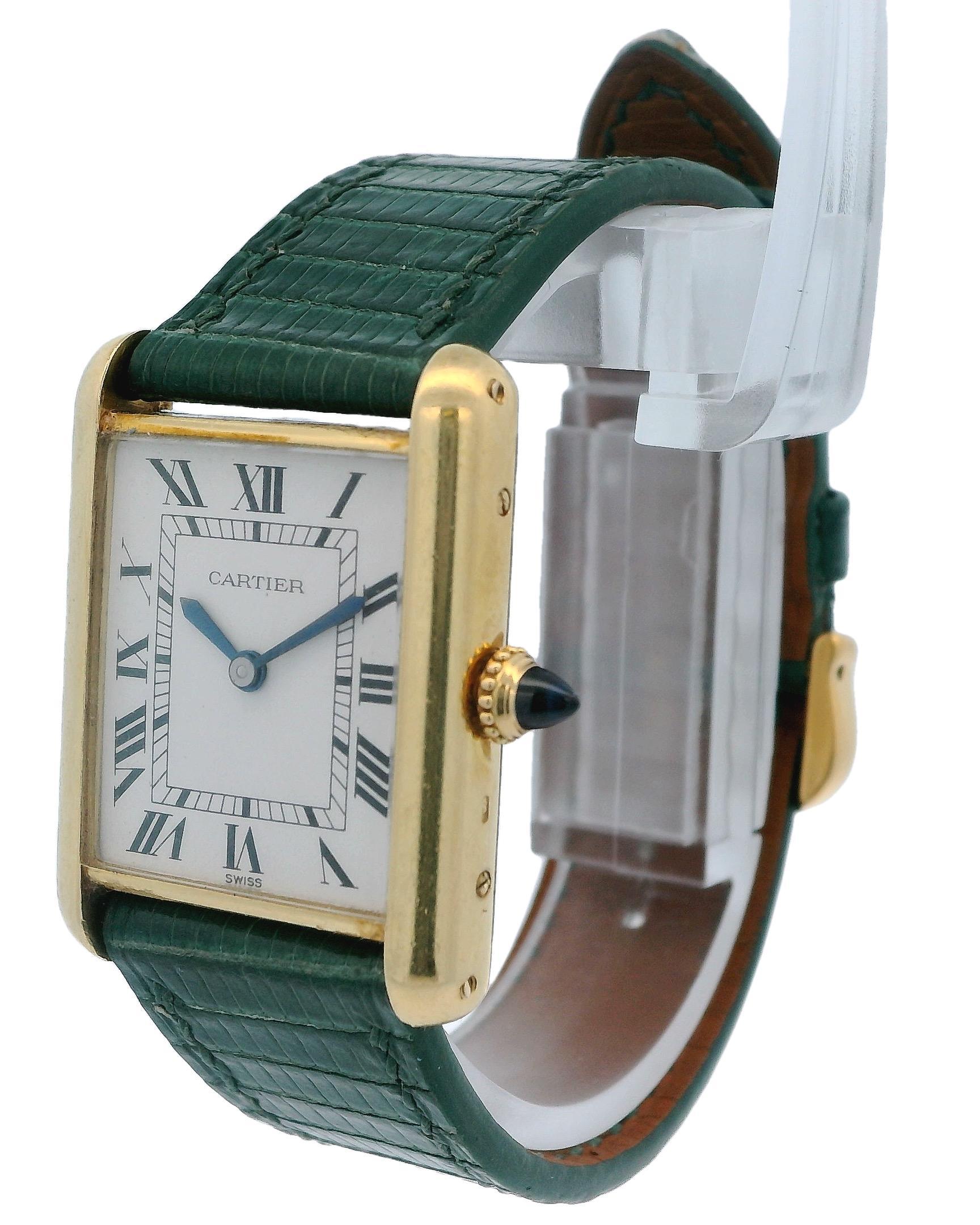 Montre Cartier Tank en or jaune 18 carats. 23,3 x 30,7 mm, de la branche à la branche, avec une lunette lisse. Cadran blanc avec index en chiffres romains noirs. Bracelet en lézard vert et boucle plaquée or. La montre s'adapte à un poignet d'une