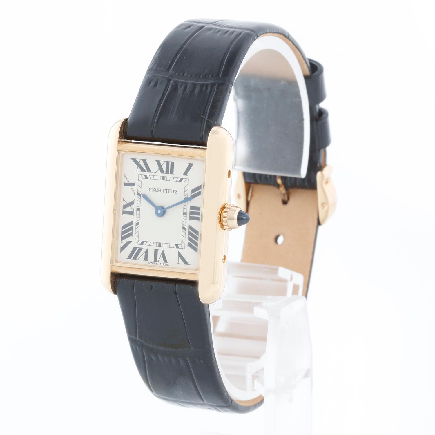 Cartier Tank 18k Yellow Gold Ladies Watch on Leather Band 2442 W1529856 - Quartz. 18k yellow gold case (22mm x 30mm). Ivory colored dial with black Roman numerals. Black strap band with 18k yellow gold Cartier buckle. Pre-owned with custom box. 
