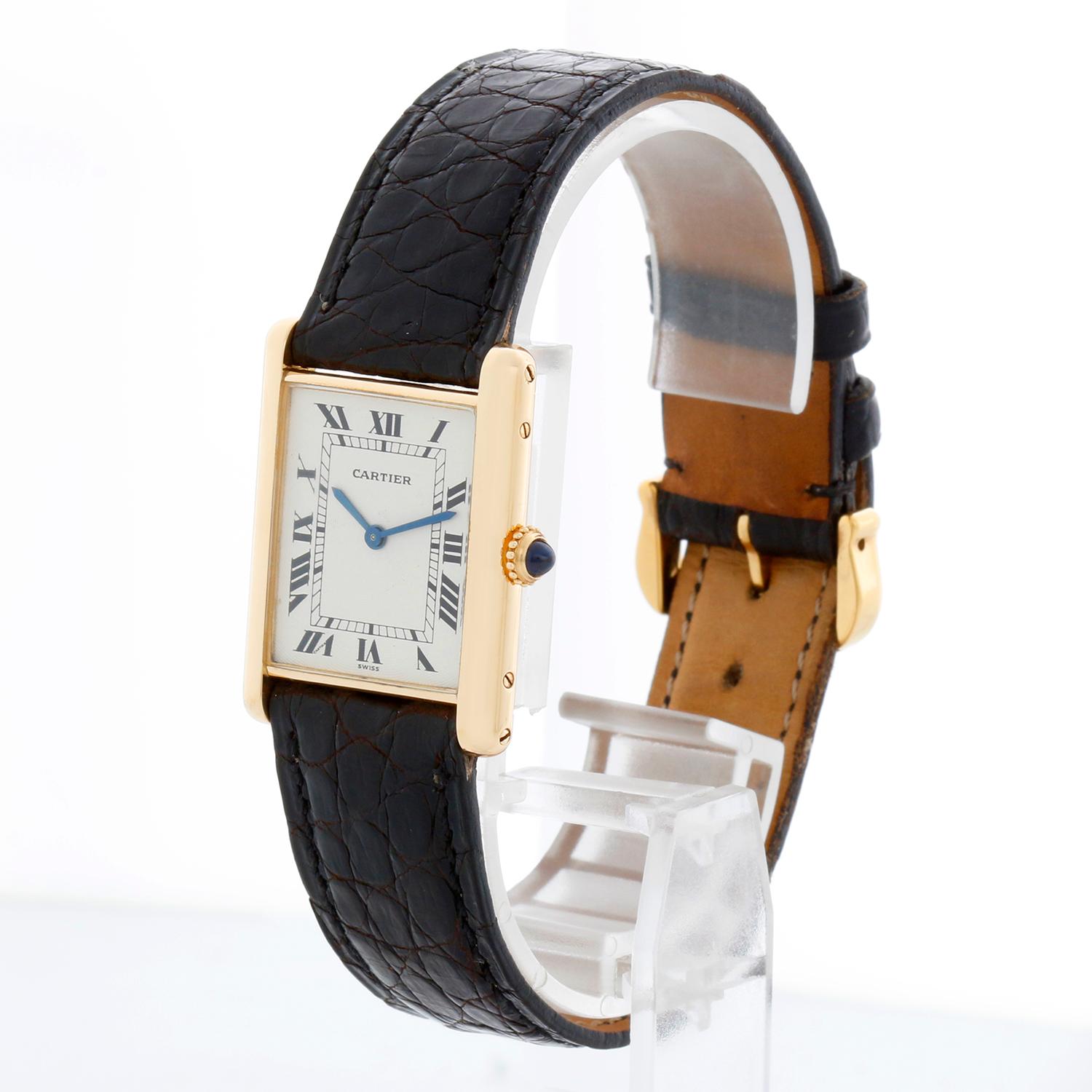 Cartier Tank 18K Yellow Ladies Watch - Manual winding. Tank. 18k yellow gold case back (24mm x 30mm). White dial with black Roman numerals. Black Cartier strap with Cartier tang buckle. Pre-owned with Cartier Pouch.

