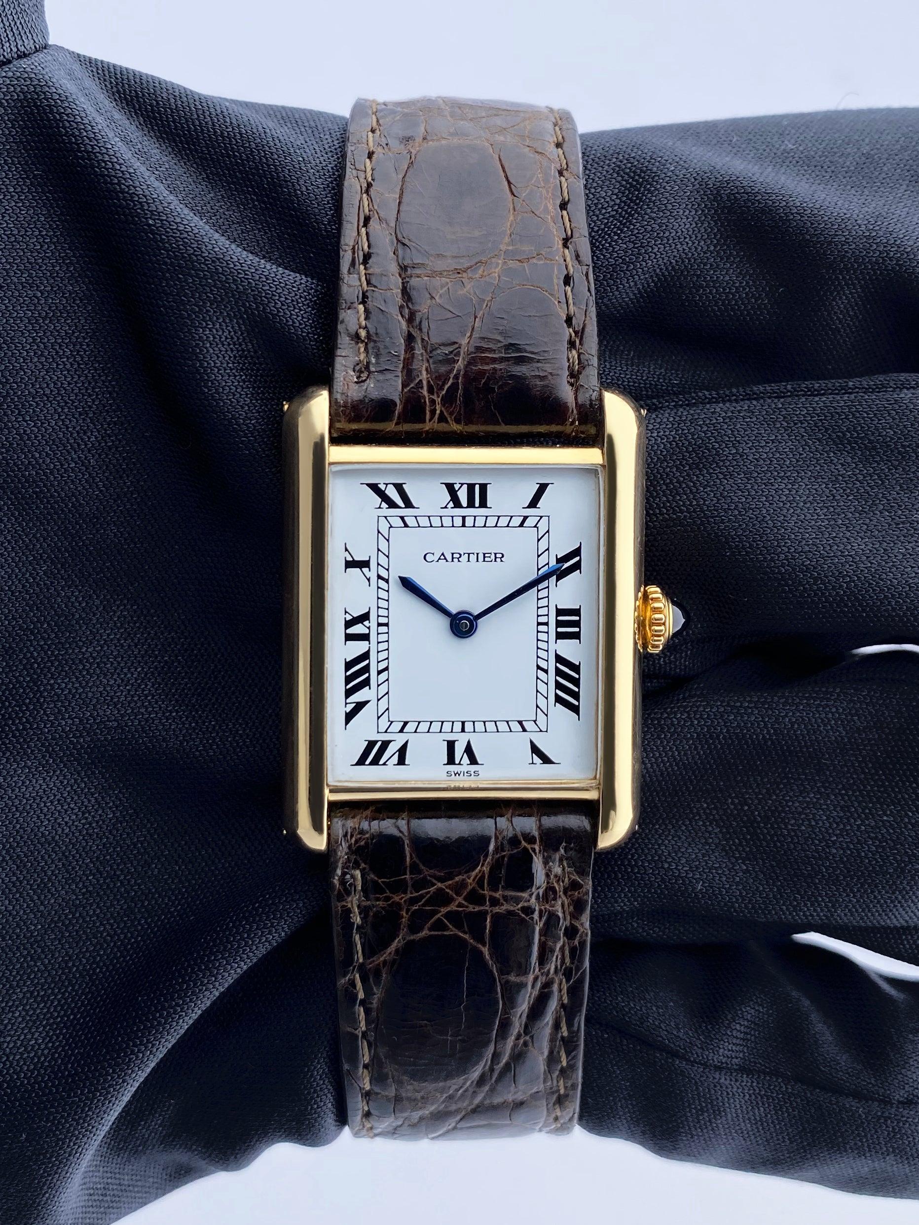 Cartier Tank 78086 Ladies Watch. 24mm 18K yellow gold case. White dial with blue steel hands and Roman numeral hour markers. Minute markers on the inner dial. Brown crocodile leather strap with 18K yellow gold buckle. Will fit up to a 7.25-Inch