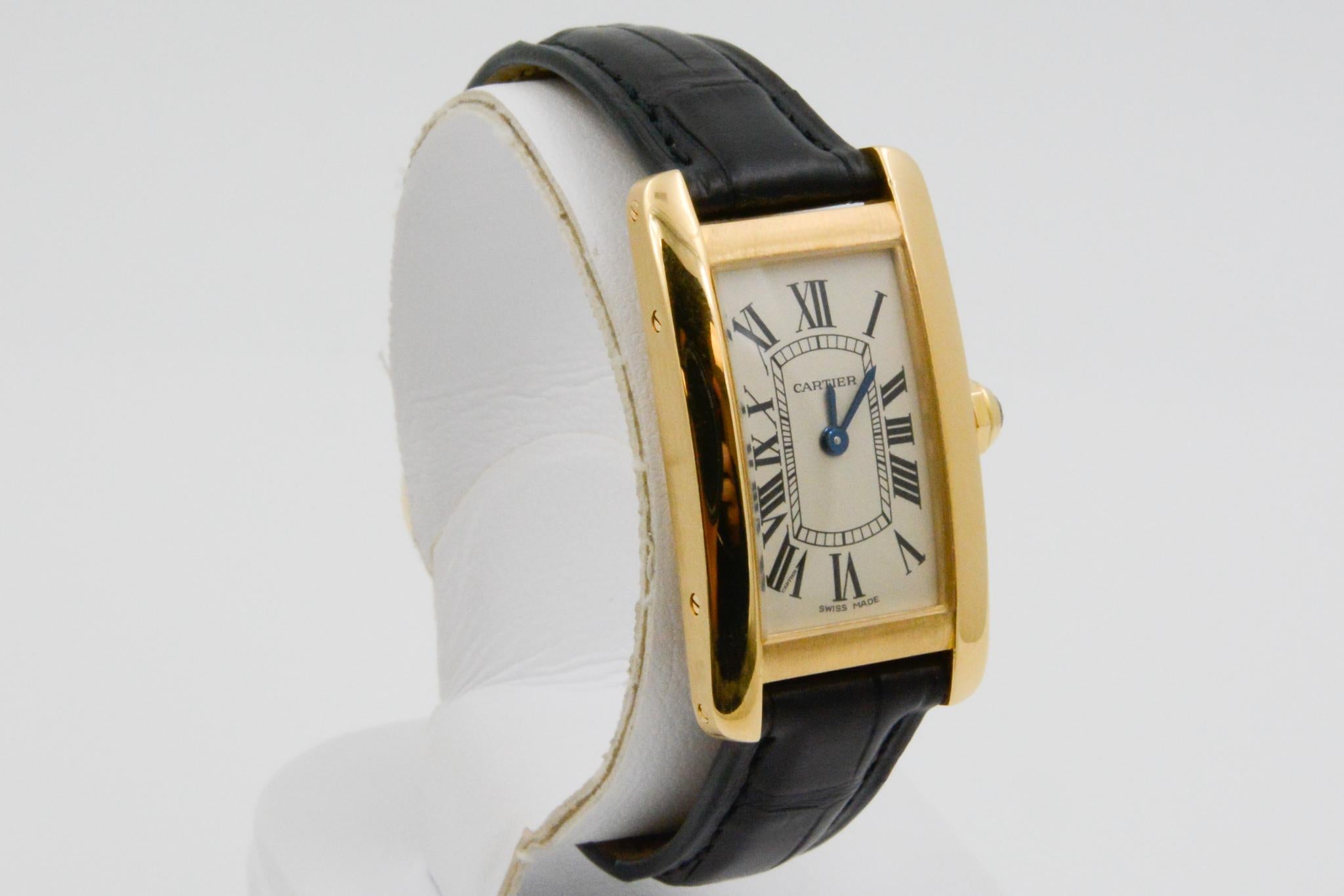 This circa 2000 CPO Cartier Tank Americain timepiece features a small 18k yellow gold rectangle ivory roman dial with a black crocodile strap and tang buckle. The watch has saphire crystal and quartz movement. 

