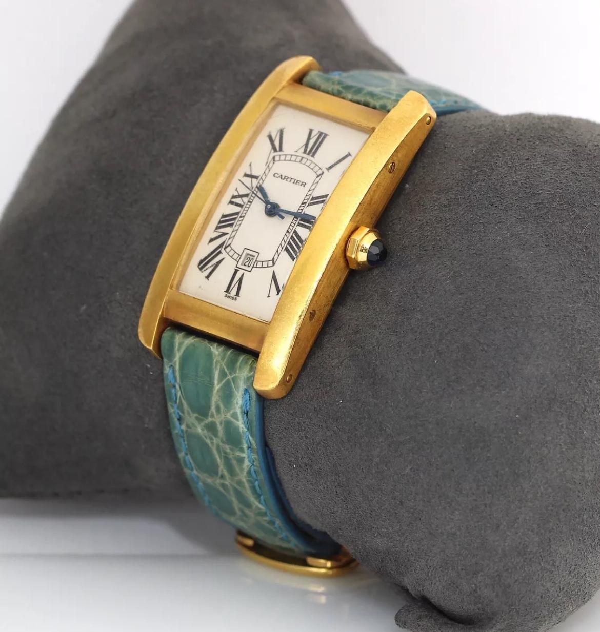 Elevate your style with this luxurious Cartier Tank Américaine wristwatch Reference number 1725. Crafted in 18k yellow gold with a rectangle case and a teal blue alligator band, this watch exudes elegance and sophistication. The Roman numeral