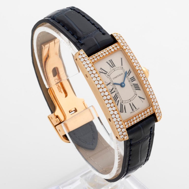 Our very rare lady Cartier Tank Americaine , reference 2482 , features a 18k yellow gold case set with diamonds, and we have fitted a new deep blue Cartier strap to its original 18k yellow gold deployant Cartier clasp and a quartz movement. The case
