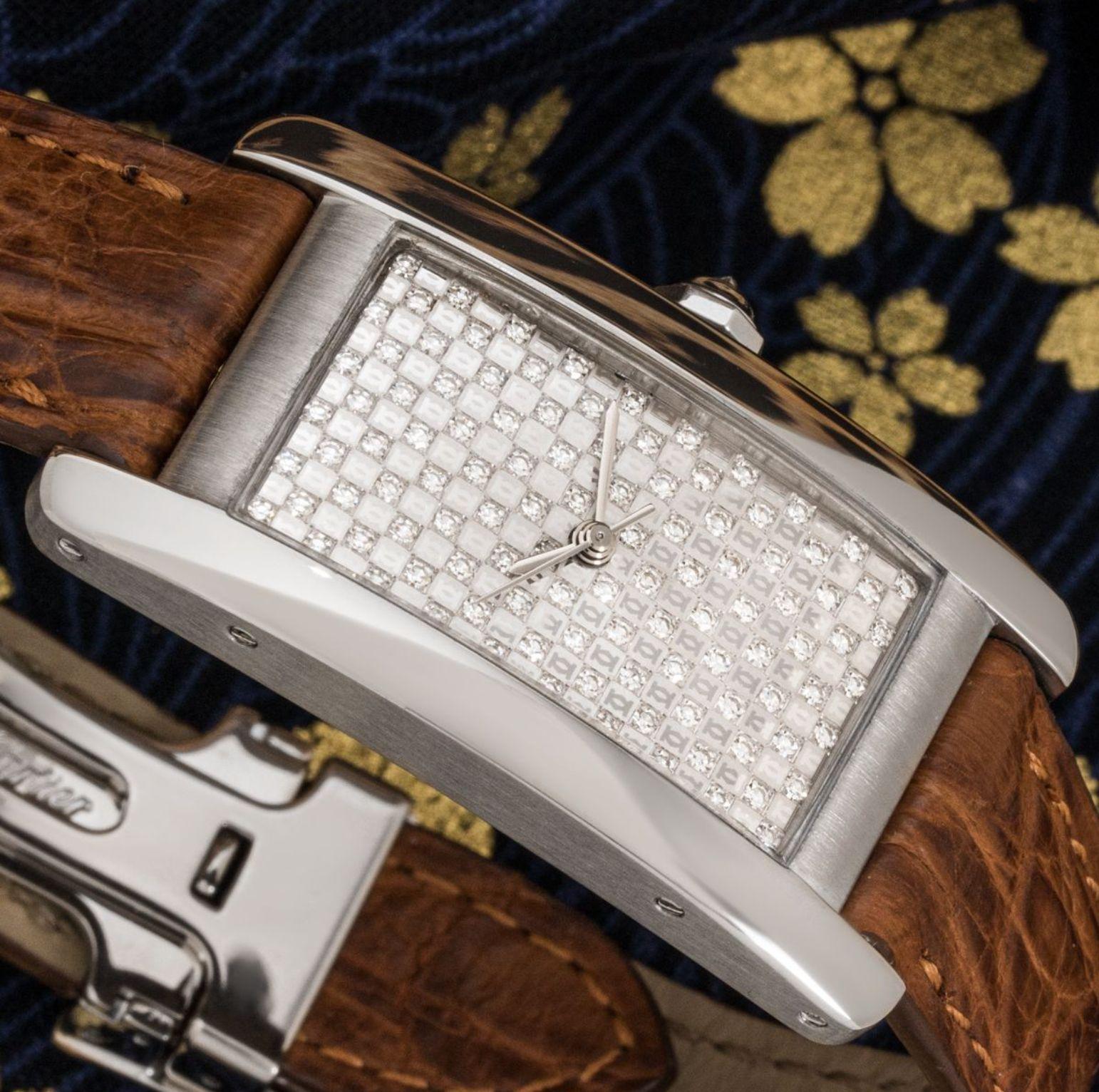 A ladies white gold Tank Americaine by Cartier. Featuring a distinctive pave set diamond dial with a white gold bezel and a crown set with an inverted diamond.

Fitted with a sapphire glass, a self-winding automatic movement and a Cartier brown