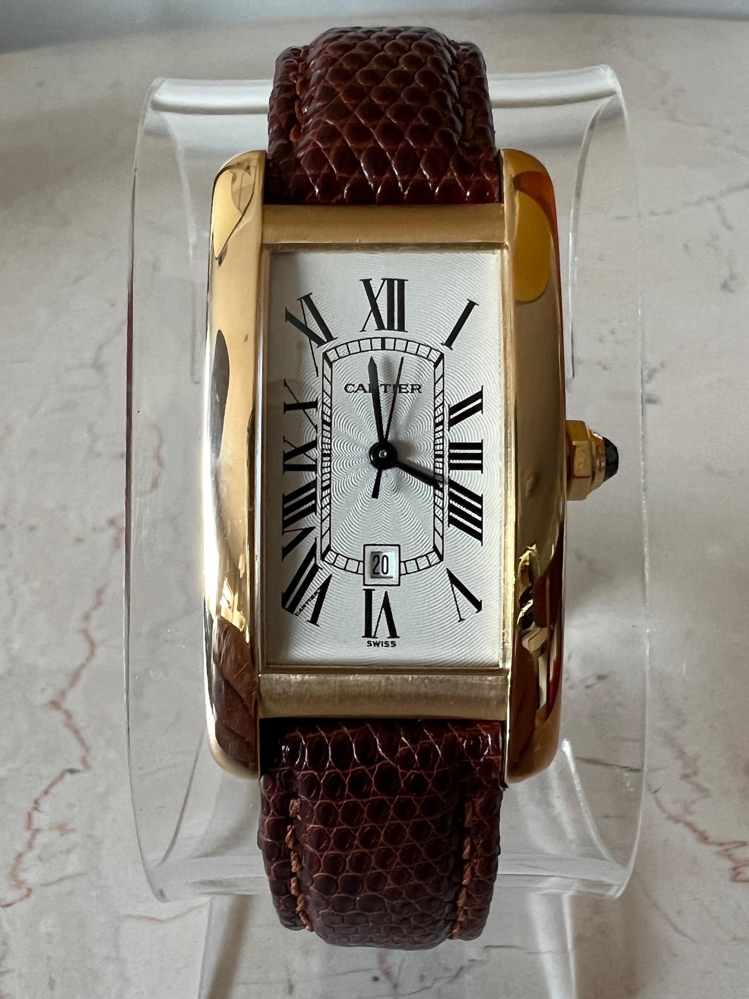 A beautiful Cartier Tank Americaine in yellow 18k gold, automatic. Blued hands, circular crown set with faceted blue sapphire. Scratch resistant sapphire crystal. Silvered guilloche dial with classic, black Roman numerals. Date calendar window at 6