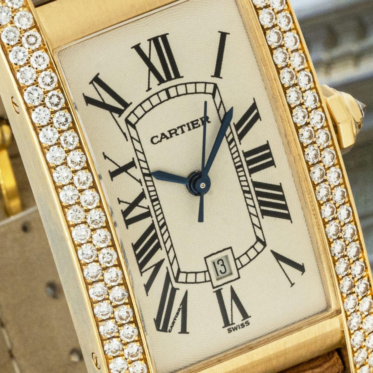 A yellow gold Tank Americaine by Cartier. Features a silver dial with Roman numerals, date display, sword-shaped hands in blued steel and a secret Cartier signature at V of VII. The piece is complemented by approximately 102 round brilliant cut