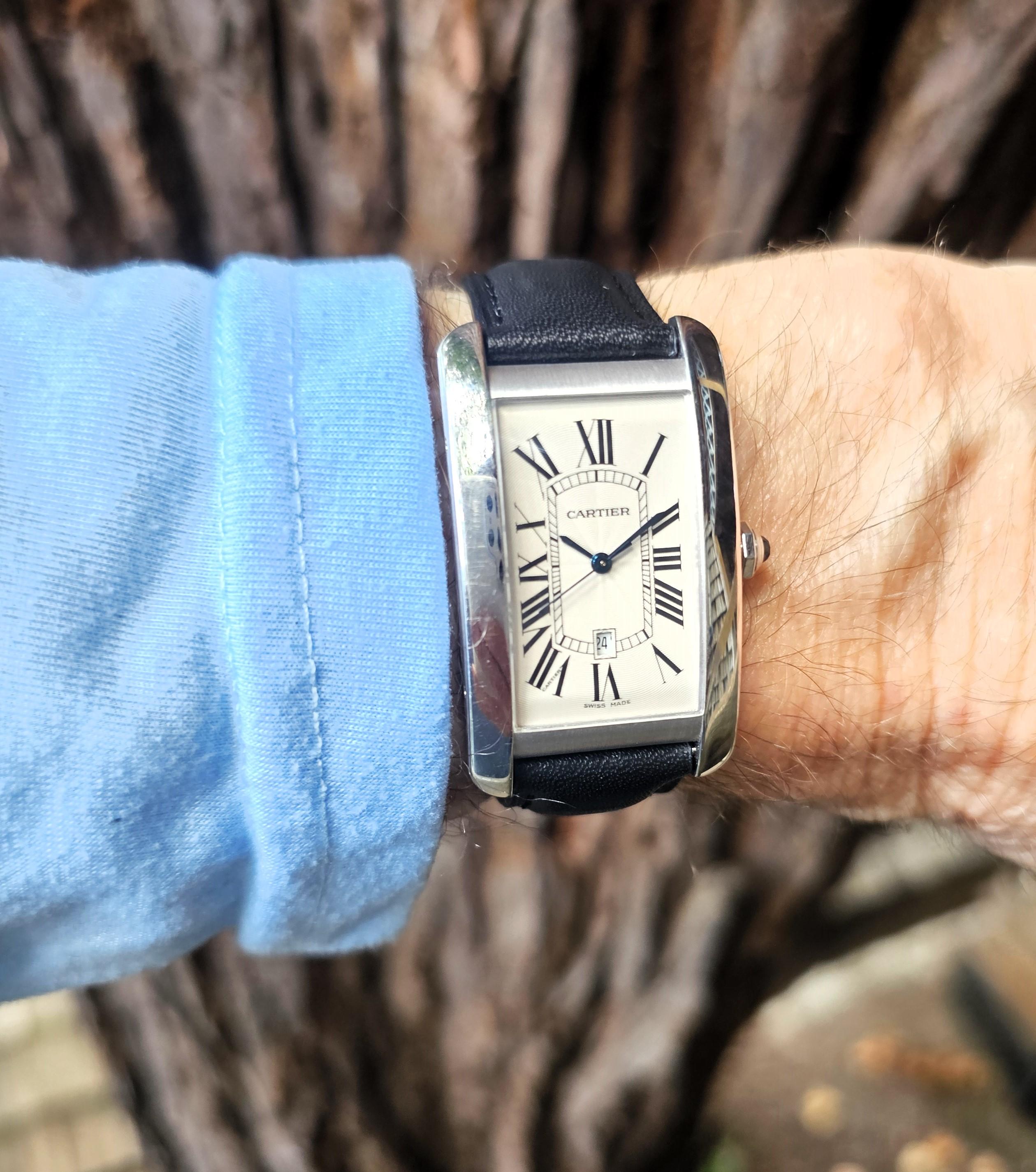 Introduction:  Cartier Tank Americane (W2603256) self - winding automatic watch, features a 18K white gold rectangular case measuring 27mm x 45mm. The dial is silver with  Guilloché pattern design.  The watch is accompanied with a new black leather